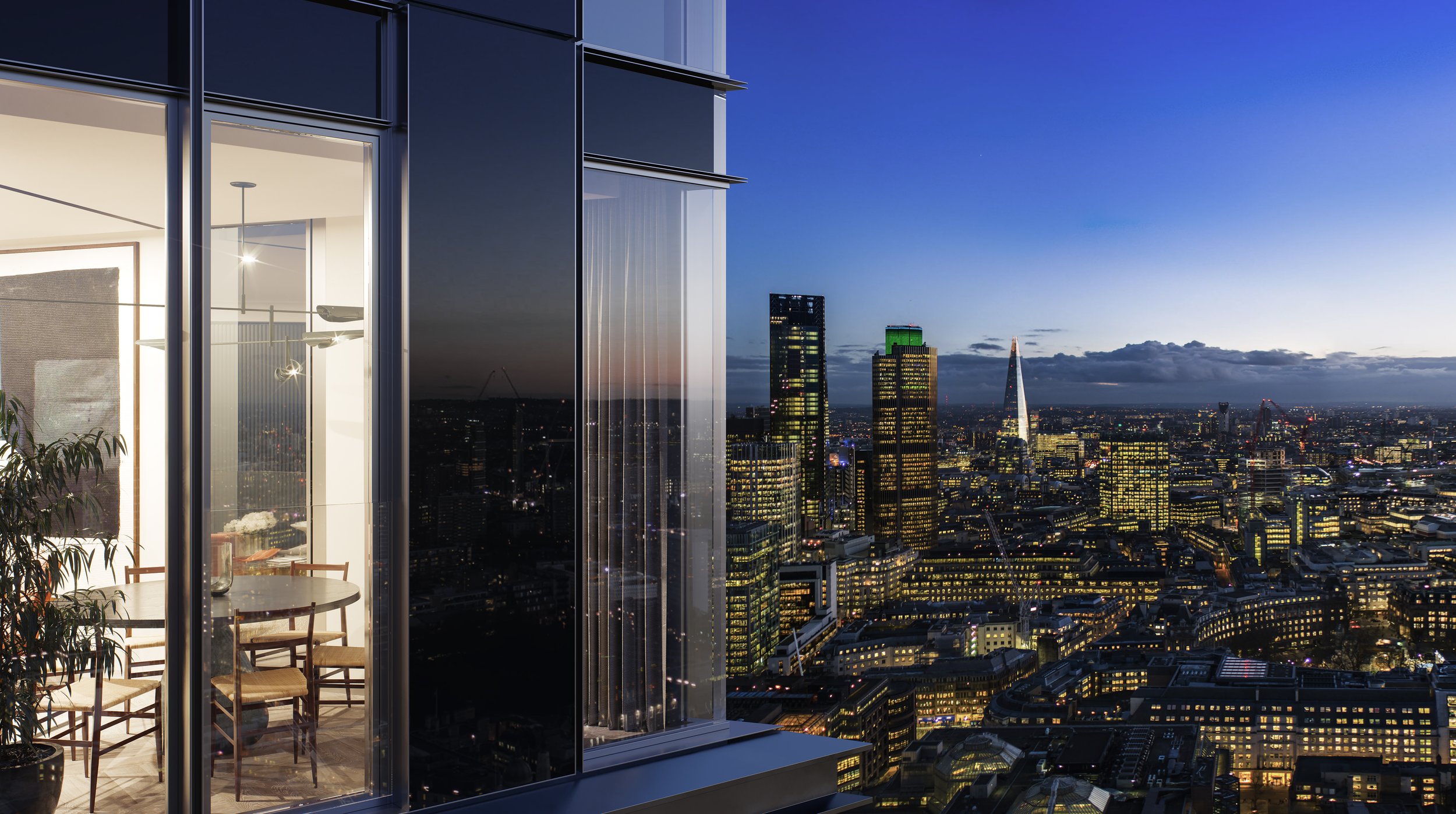 Interior of a modern apartment with glass walls, showing a dining area with a round table and four chairs, overlooking a city skyline at dusk with illuminated skyscrapers.