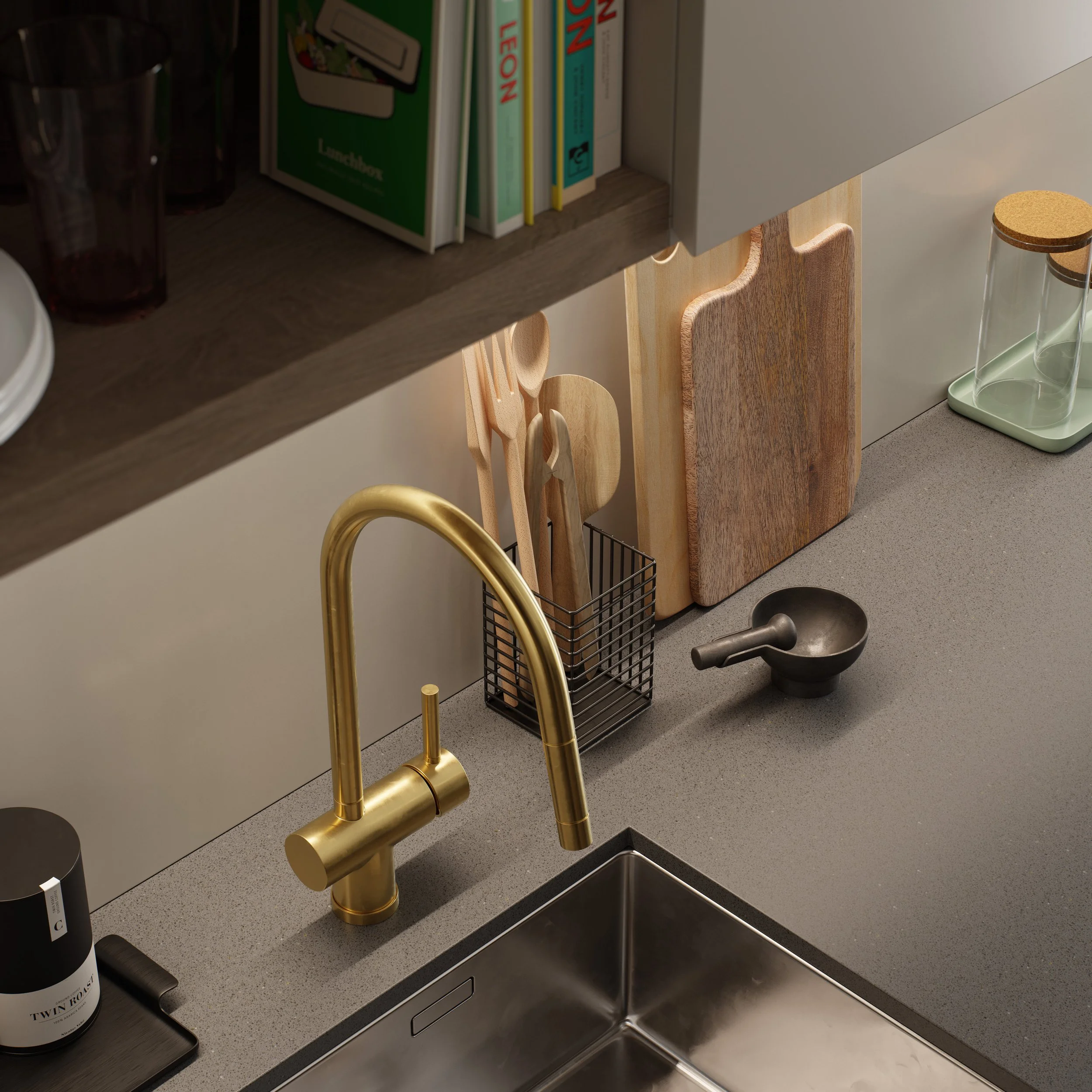 Kitchen sink with a brass faucet, various wooden cutting and serving boards, and kitchen utensils in a wire holder on the counter.