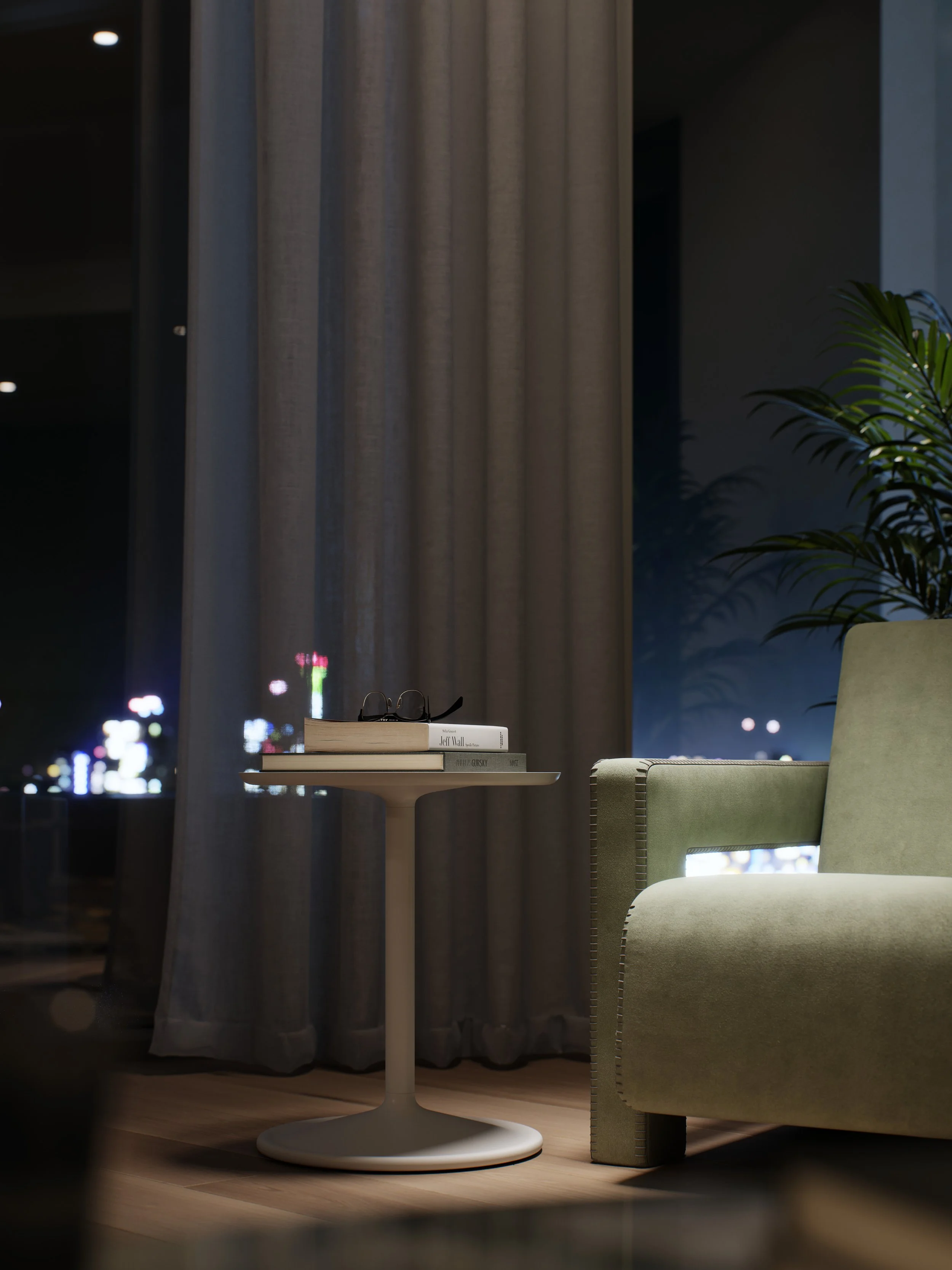 Nighttime scene showing a green armchair with nailhead trim, a small round white table with stacked books, a pair of glasses, and a plant in a pot, in front of a window with curtains and city lights outside.
