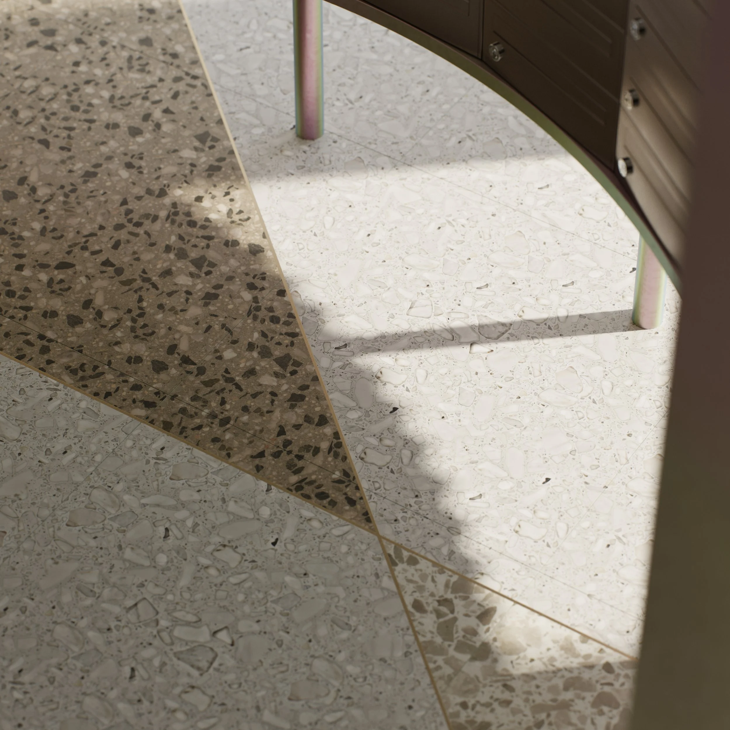 Close-up of tiled floor with two different terrazzo patterns and shadows cast by furniture.