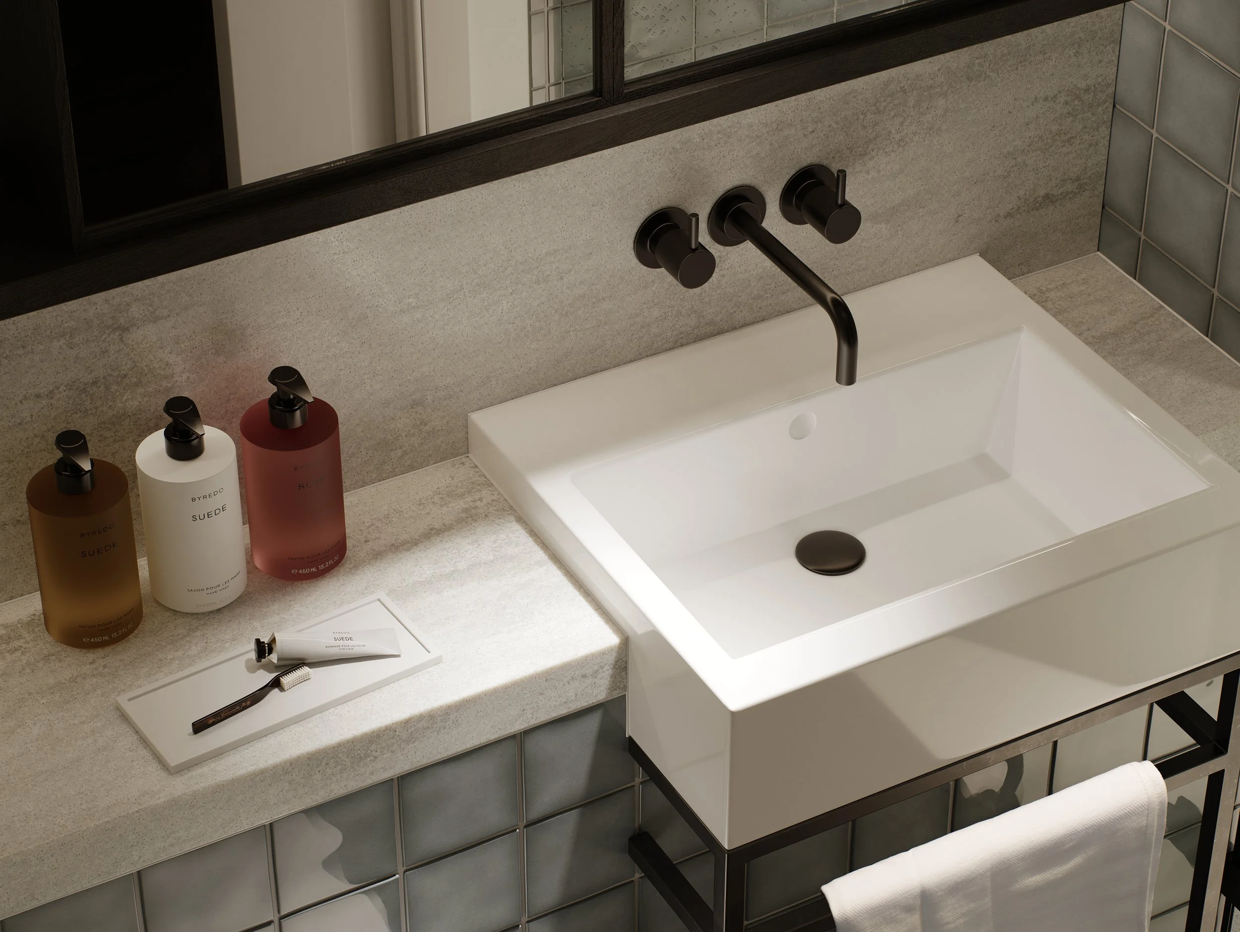 Bathroom sink with black faucet, three soap bottles labeled BYREDO in amber, white, and red, a toothbrush, and a tube of hand cream on a gray countertop with a mirror above.