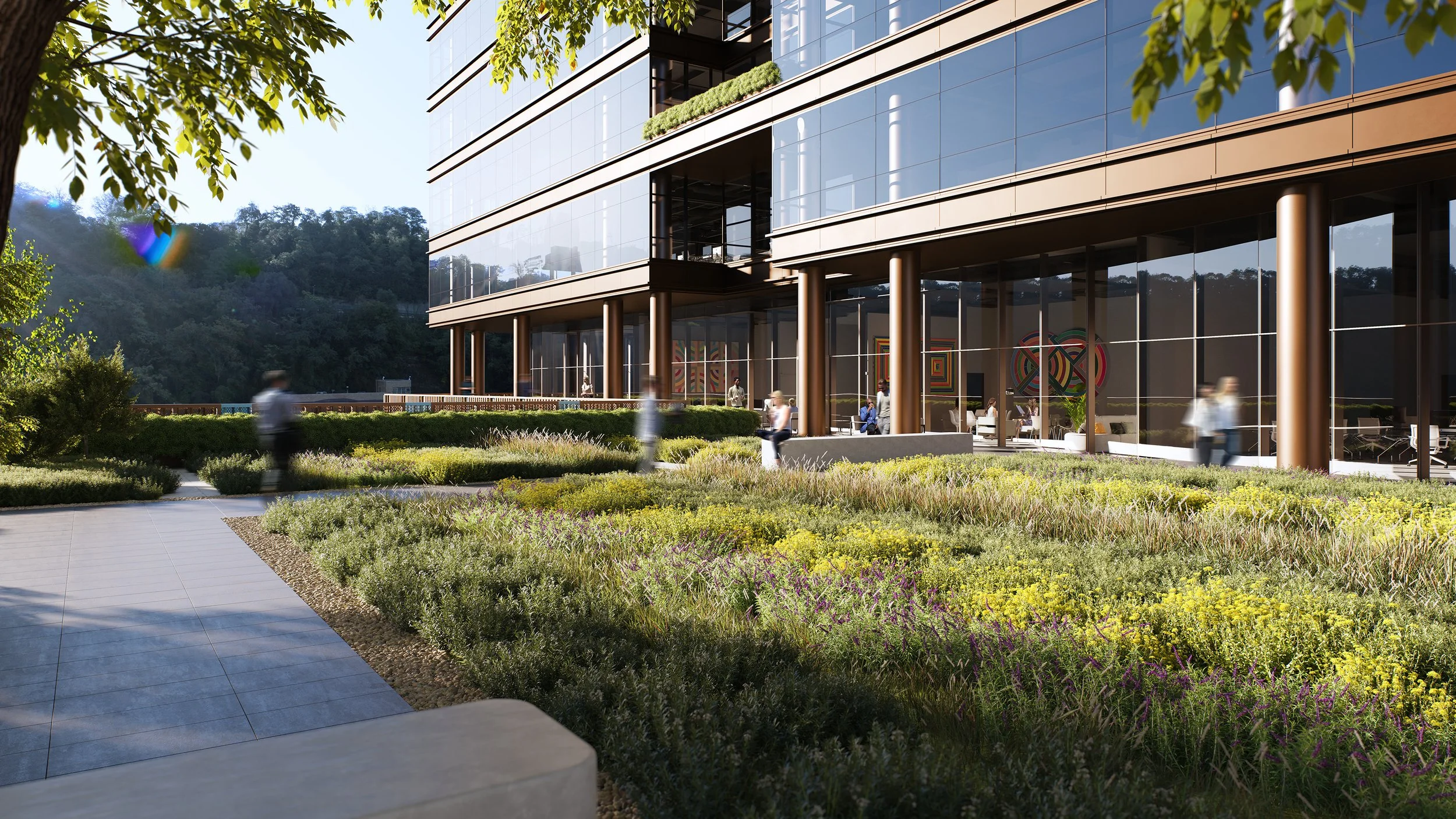 Modern office building with glass facade, surrounded by landscaped gardens and people walking outside.