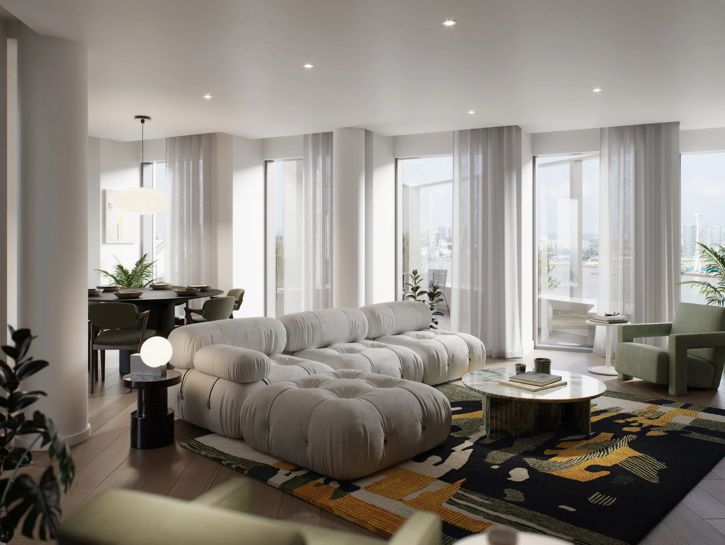 Living room with large white sectional sofa, green armchair, round coffee table, patterned area rug, and large windows with sheer curtains letting in natural light.