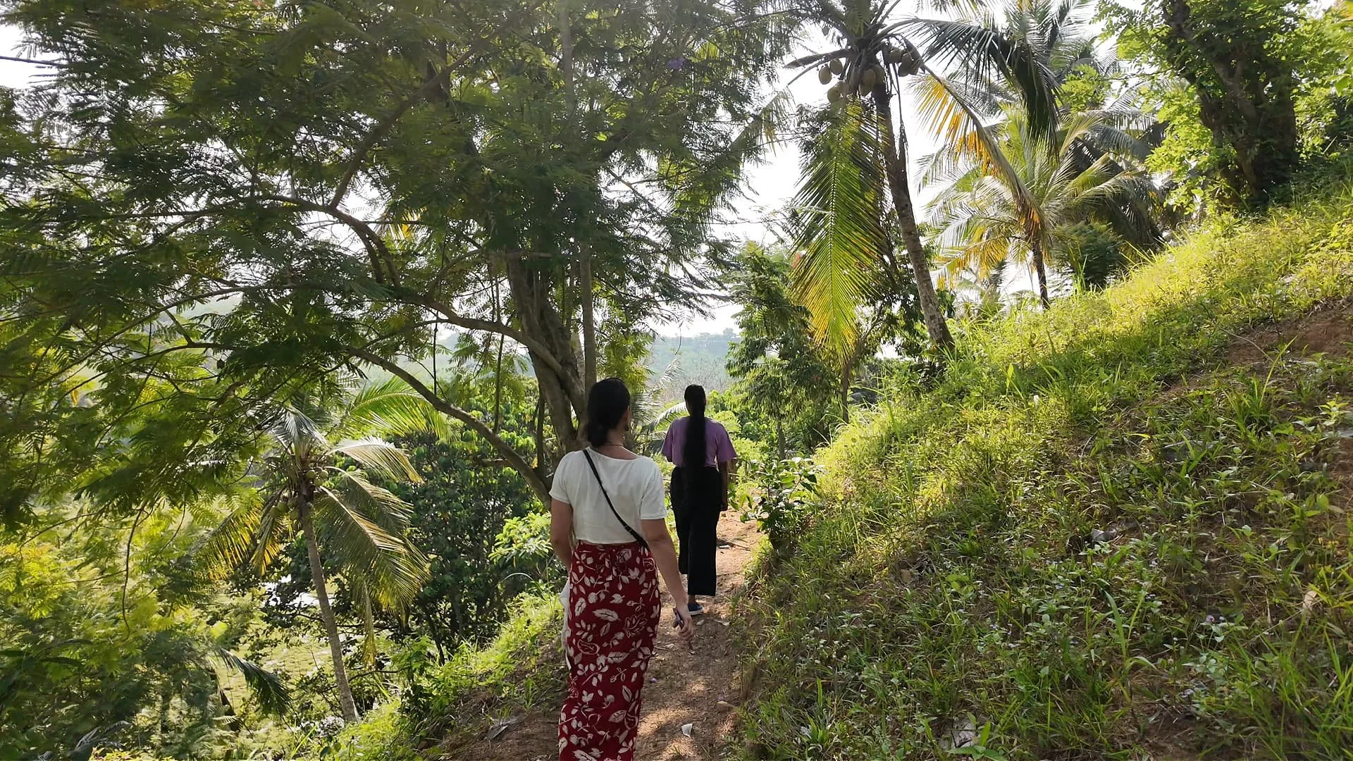 two women walking at tekanda lodge in the lush green garden