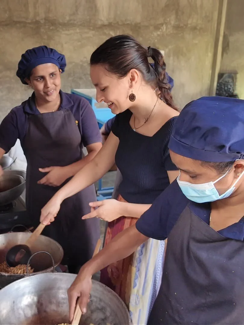 roseland coffee roasters coffee tour with two employees hand roasting coffee beans and a tourist trying to roast herself in the hill country of sri lanka