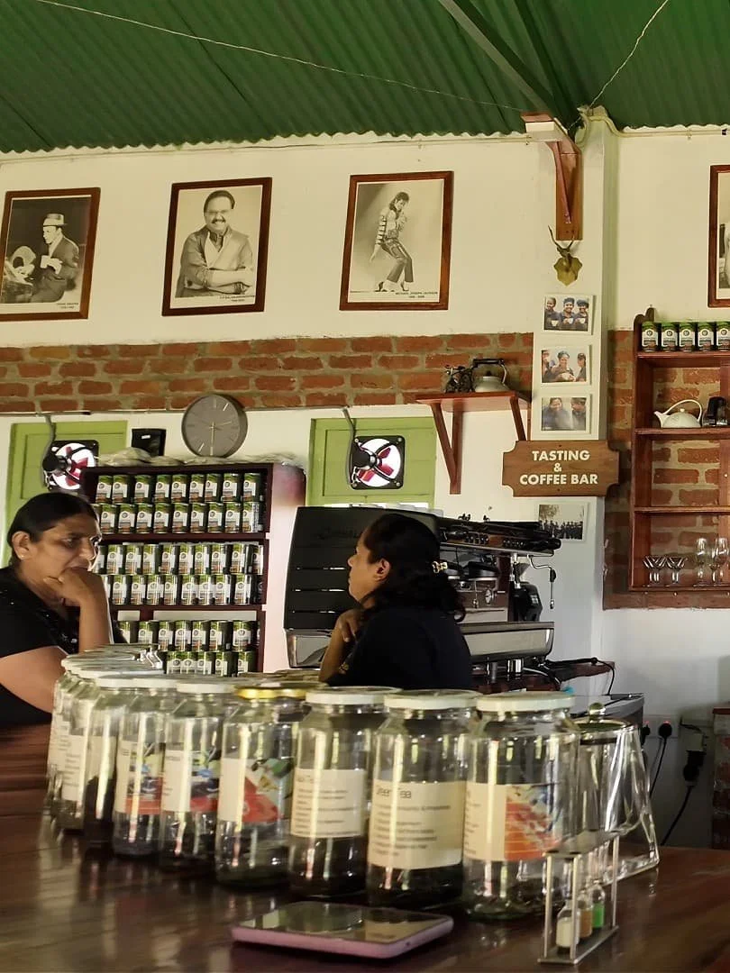 Roseland coffee roasters coffee bar with glas jars of spice mixes and tea mixes including the health benefits and two employees chatting in the background in the hill country of sri lanka