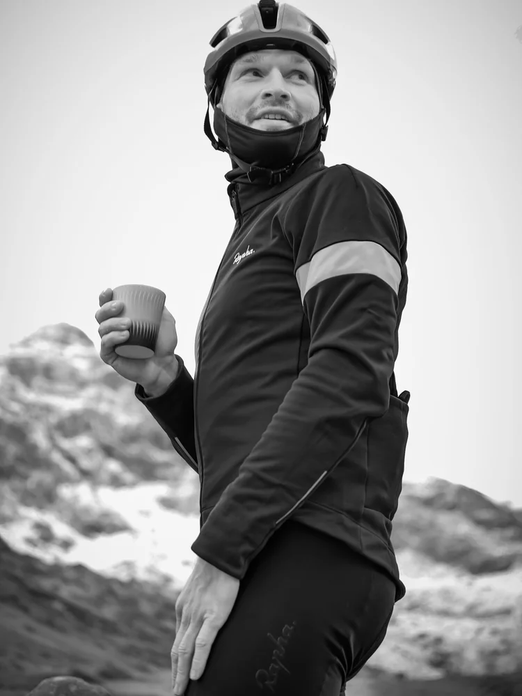 Black and white portrait of Daniil with a coffee in the mountains