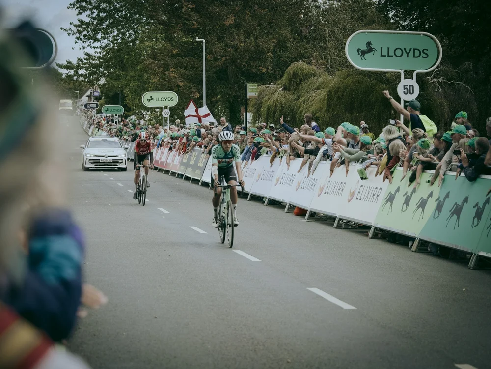 Riders sprinting for the line on a Milton Keynes street, crowds behind the barriers