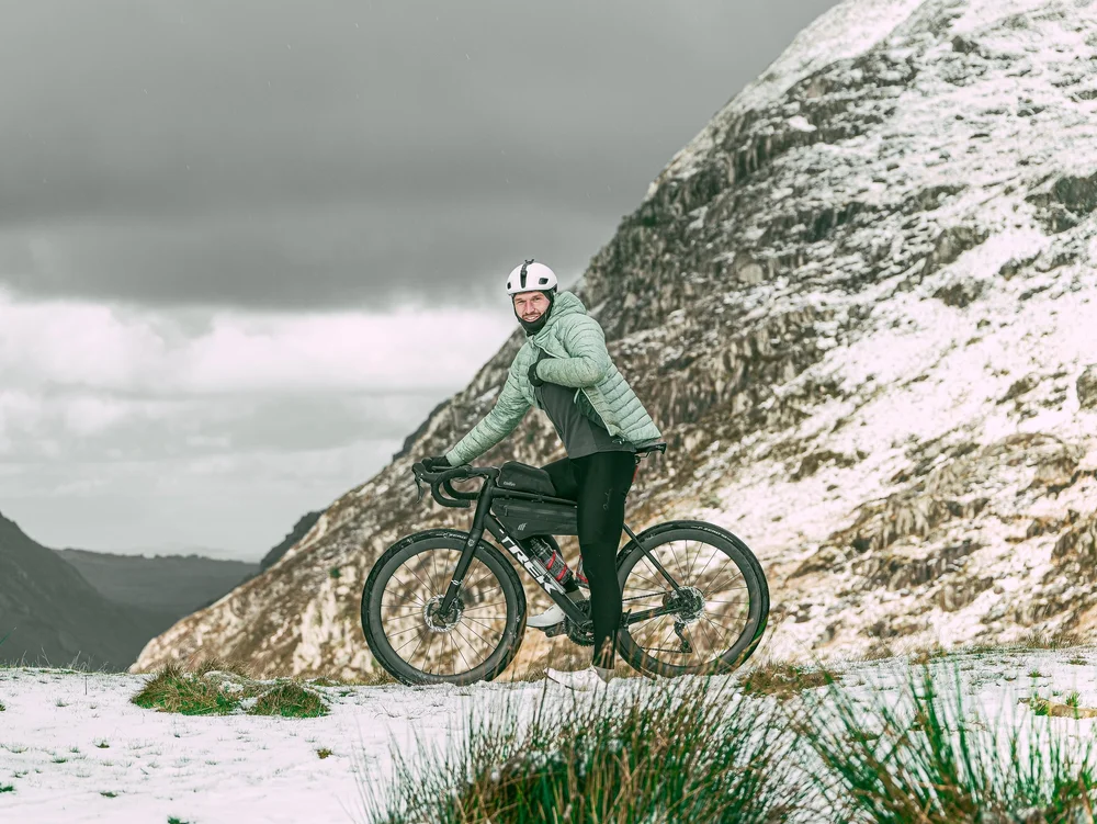 Daniil riding past a snow-dusted hillside in Wales