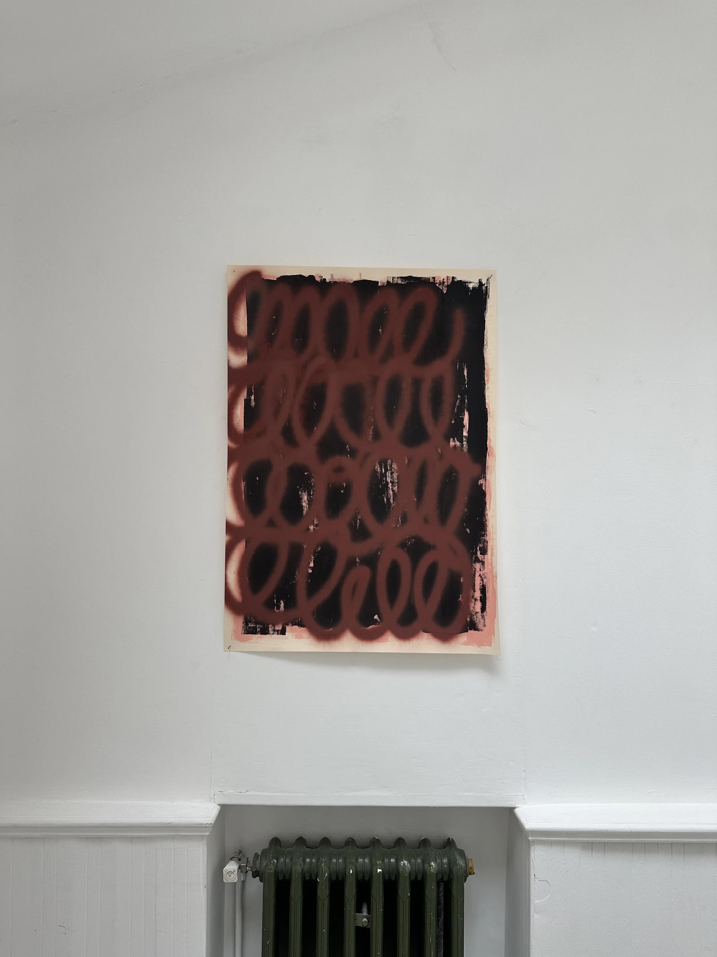 An abstract painting with black and pink colors, featuring a pattern of black ovals outlined in pink, on a beige background, hung on a white wall above a dark green radiator.