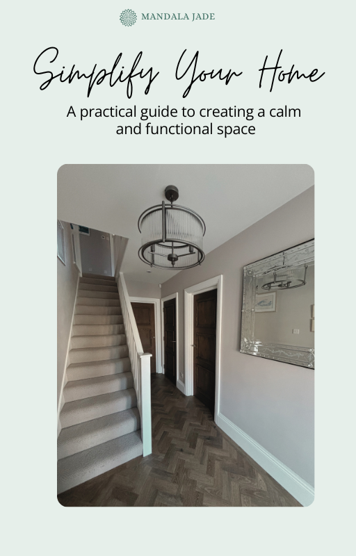 A hallway with a staircase, a large mirror on the wall, and a modern ceiling light fixture.