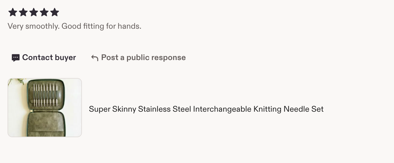 Image of a green case opened to reveal a set of stainless steel knitting needles arranged inside.