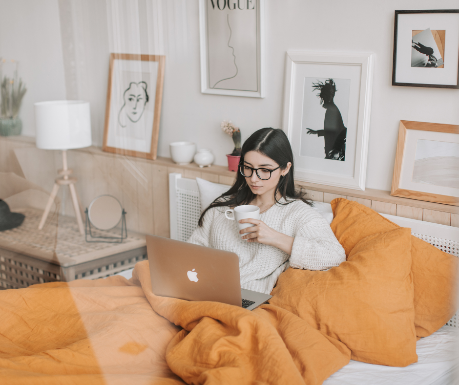 Woman sitting comfortably at home with a laptop and coffee, representing online therapy for anxiety, overwhelm, and life's everyday challenges.
