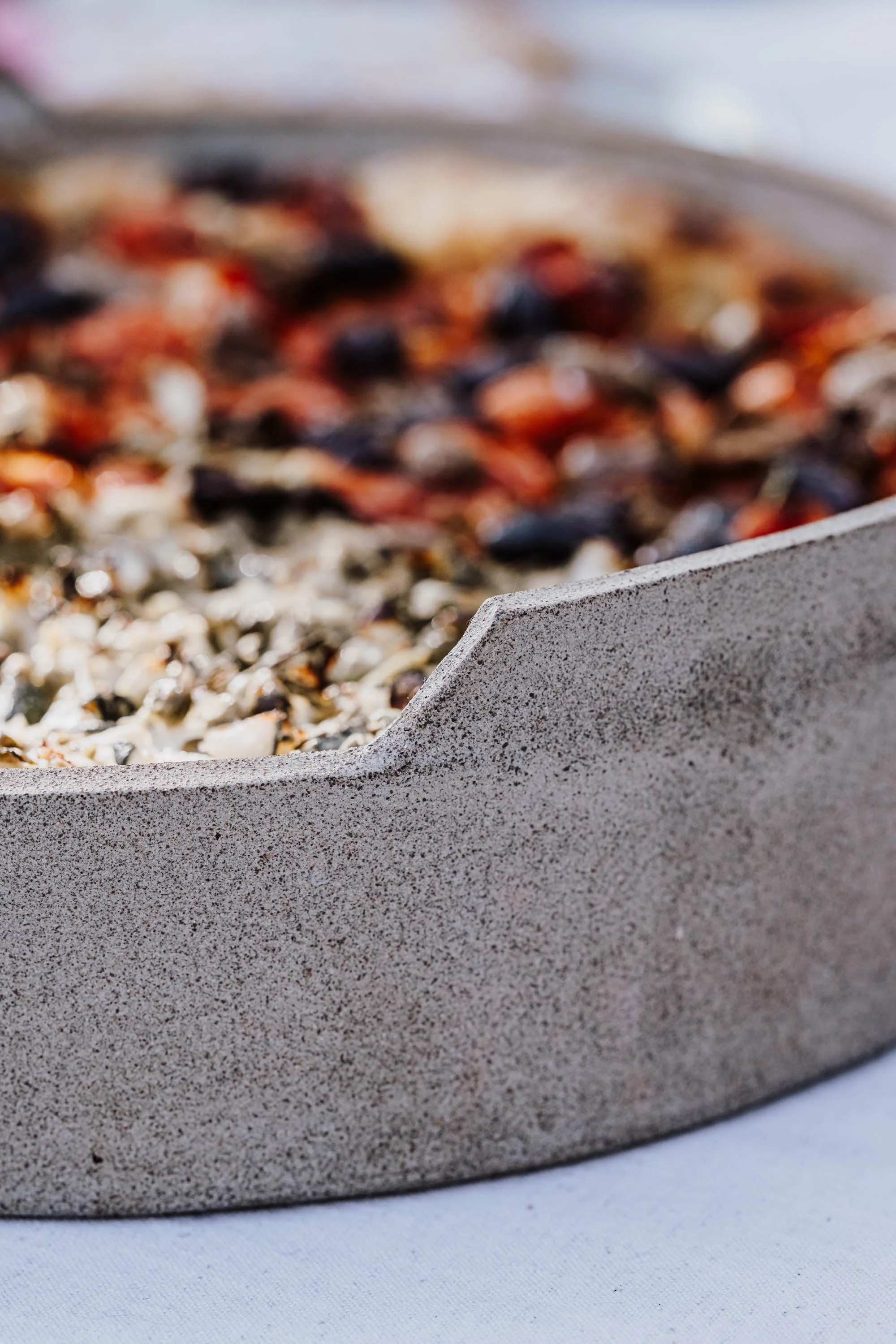 Nahaufnahme einesBackofens mit Pizza, die auf einem Steinbackofen gebacken wird.