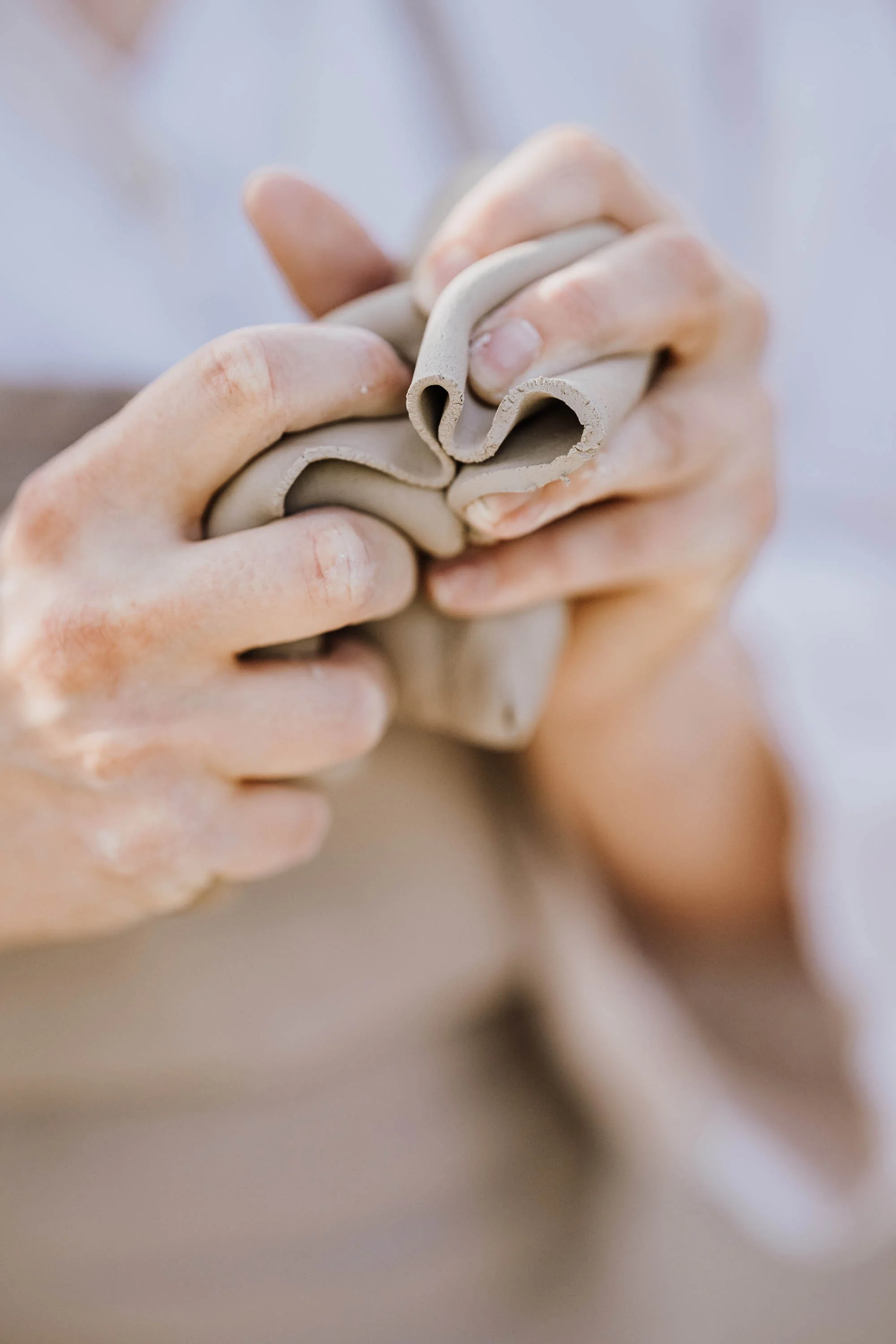 Nahaufnahme von Händen, die Ton formen.