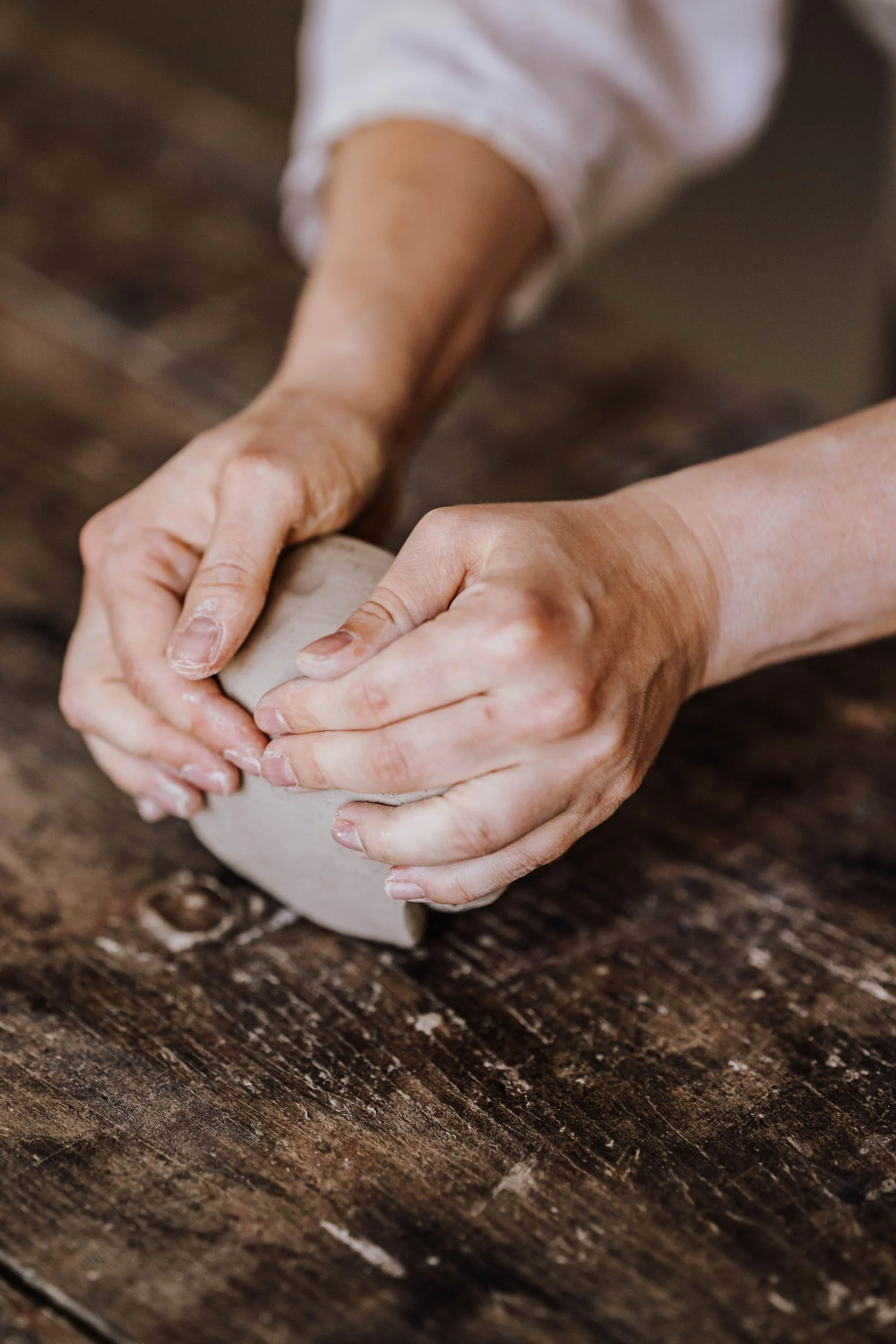 Handmodel, die Ton formt auf einem Holzarbeitstisch