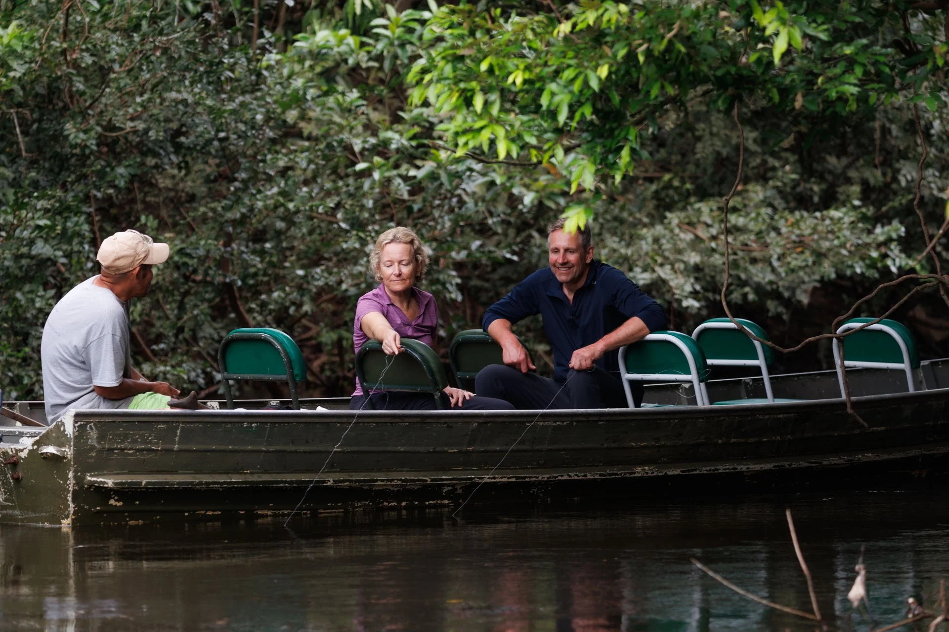 A man and a woman fish from a boat in a remote part of the Guyanese rainforest