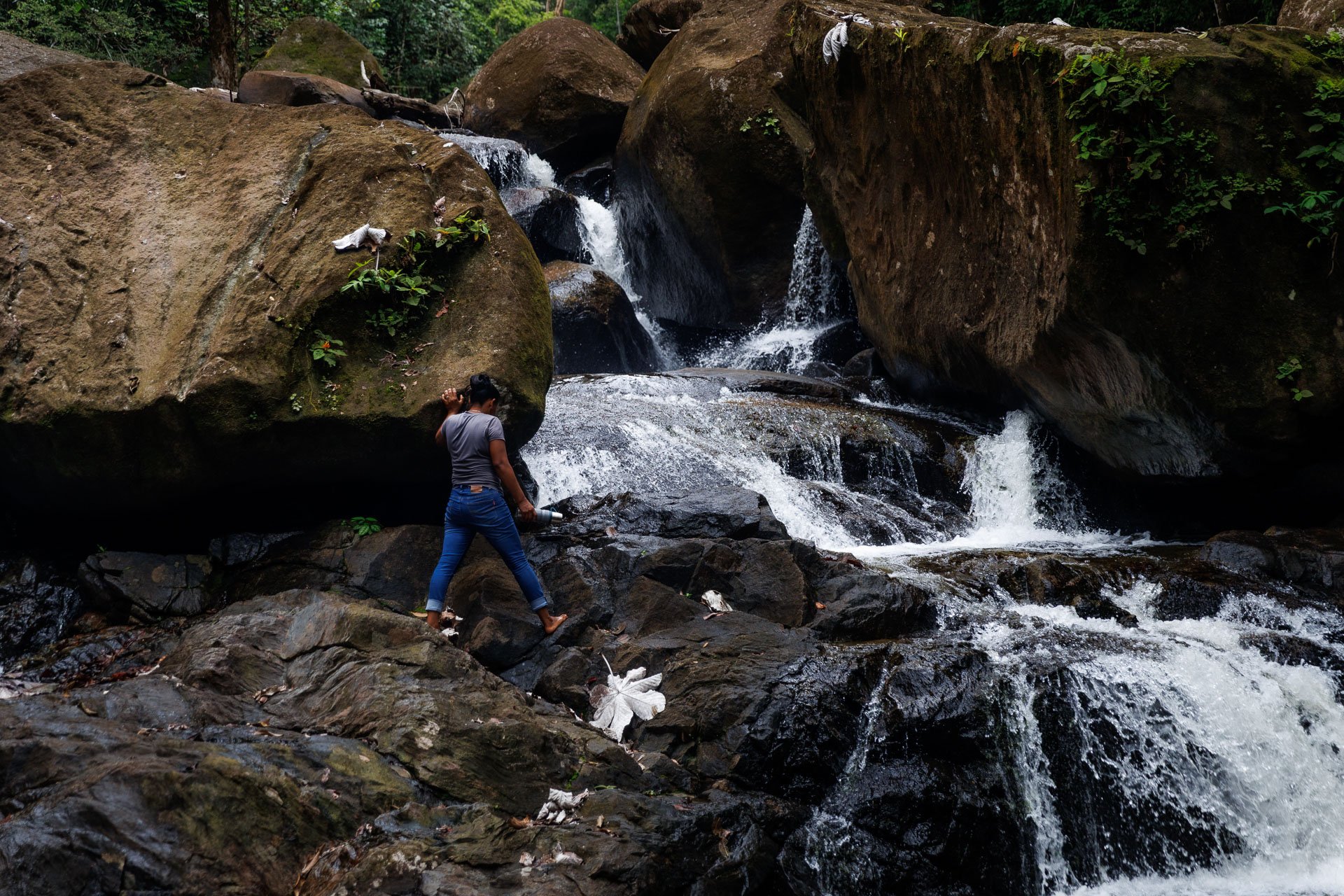 A woman stands on a waterfall during a tailor-made trip to Guyana