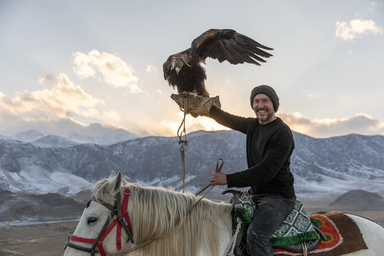 Eagle hunter in Kyrgyzstan sitting on a horse with a golden eagle on his arm. 