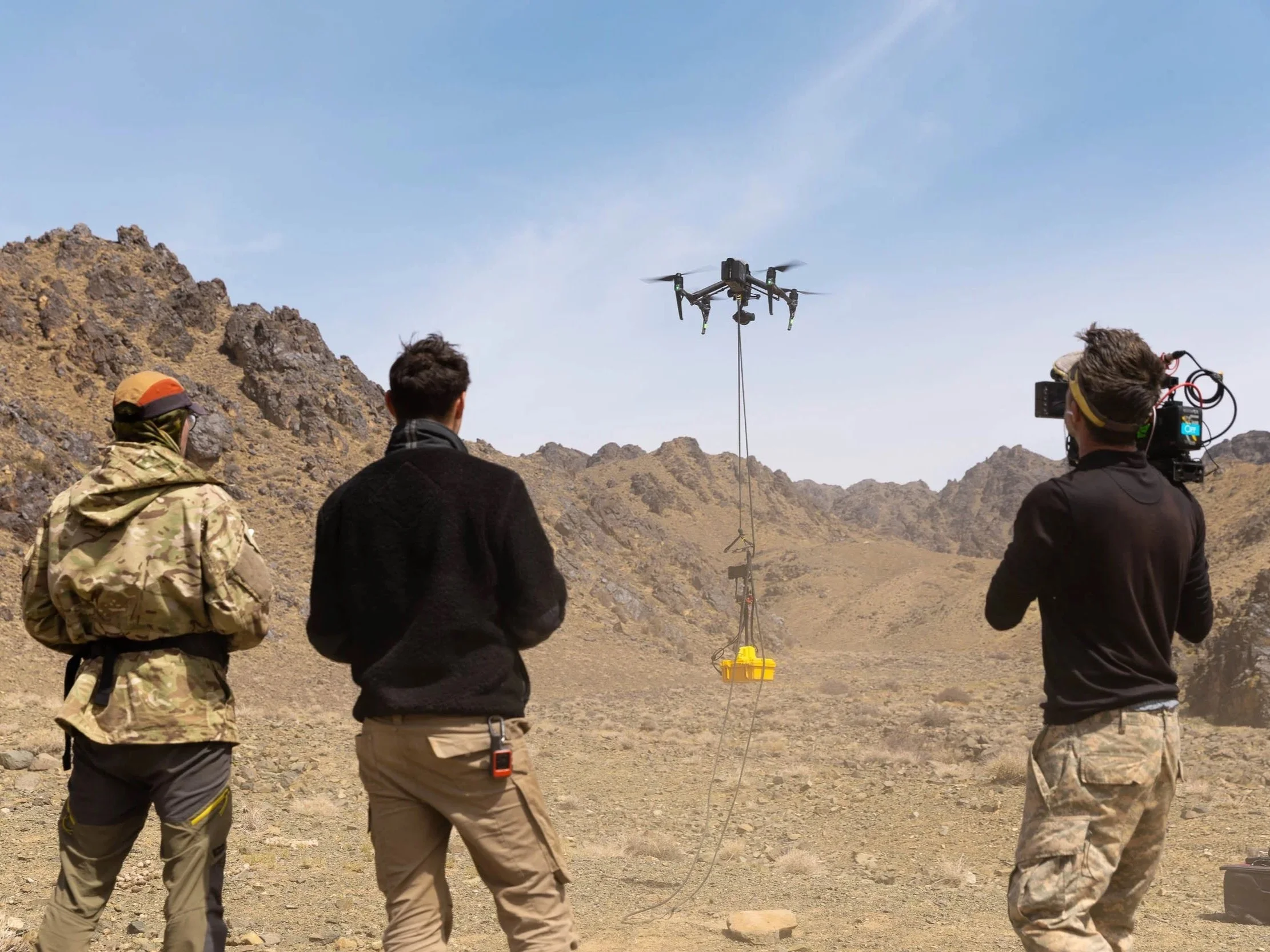 Men fly a drone to search for snow leopards in Kyrgyzstan
