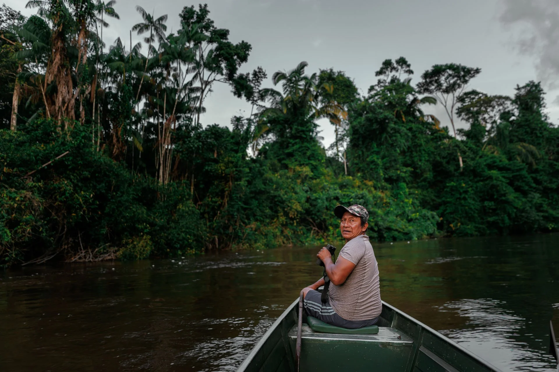 A man in a canoe in the Guyanese rainforest