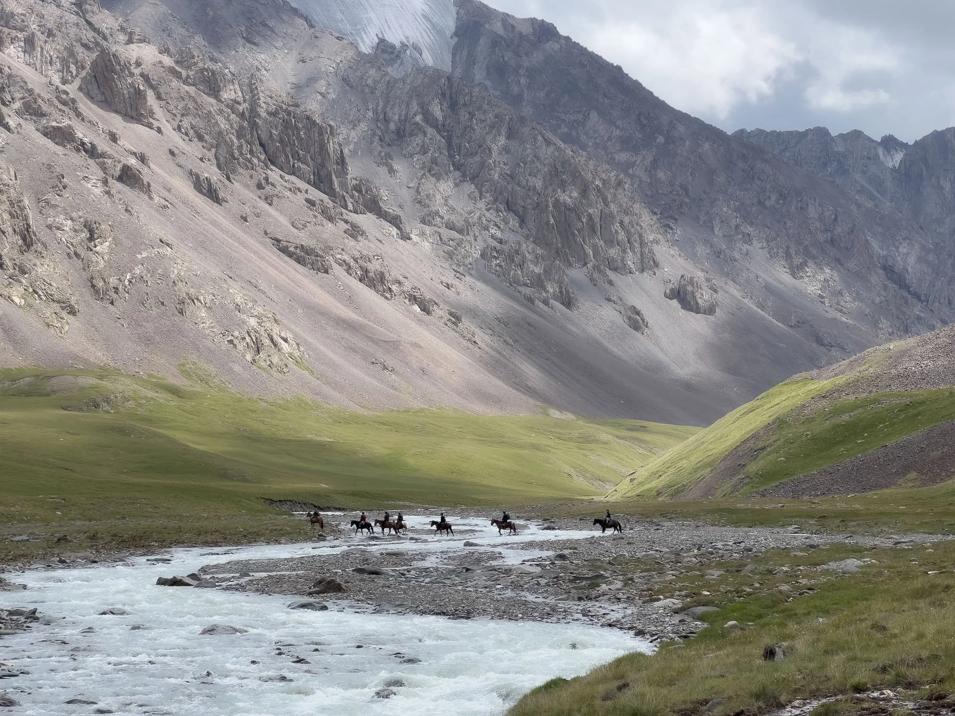 Horse riders in a valley in Kyrgyzstan tracking wildlife