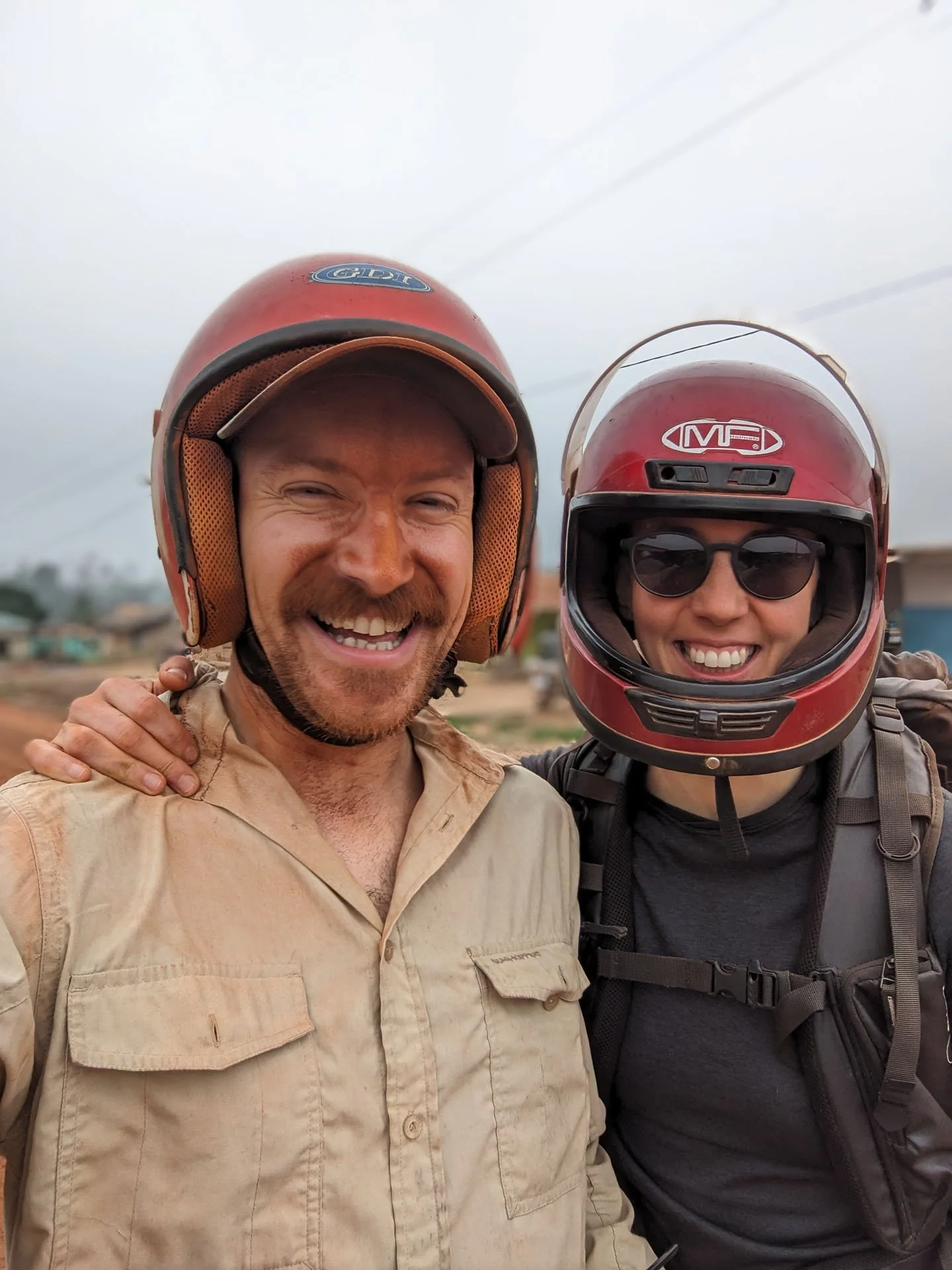 Two people wearing motorcycle helmets during a private tour