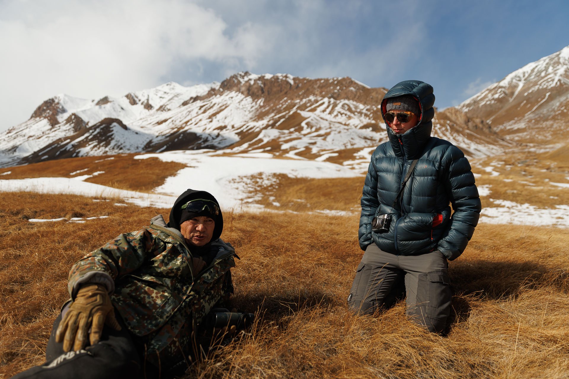 Two people talking in the mountains searching for snow leopards in Kyrgyzstan