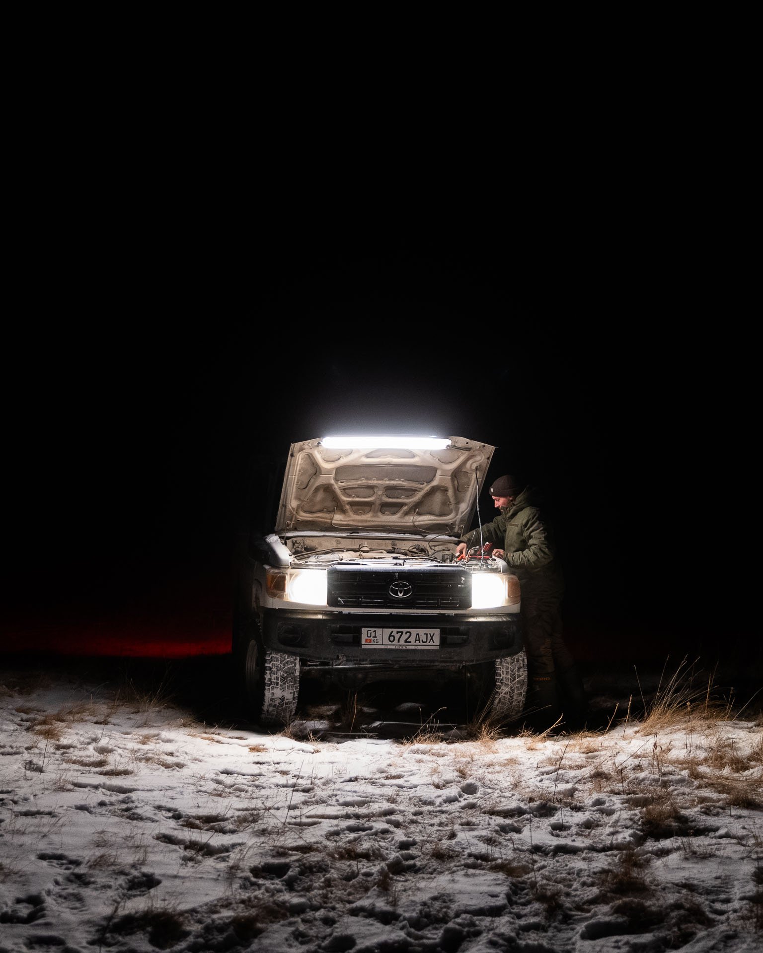 A person checking a 4x4 in a remote part of Kyrgyzstan searching for snow leopards