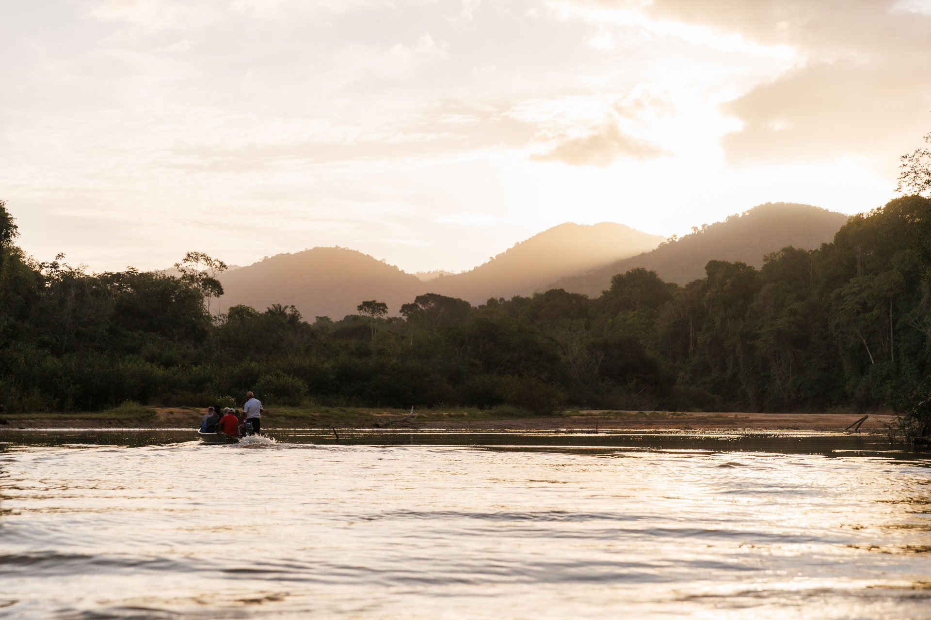 A group on a canoe boat at sunset in the Rupununi, Guyana