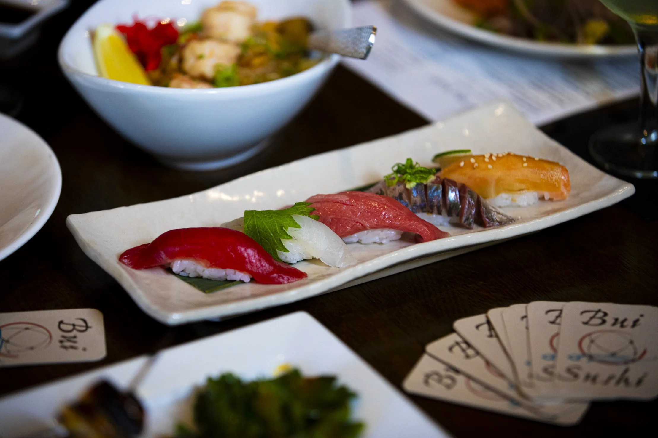 Assorted sushi pieces with raw fish on a rectangular plate