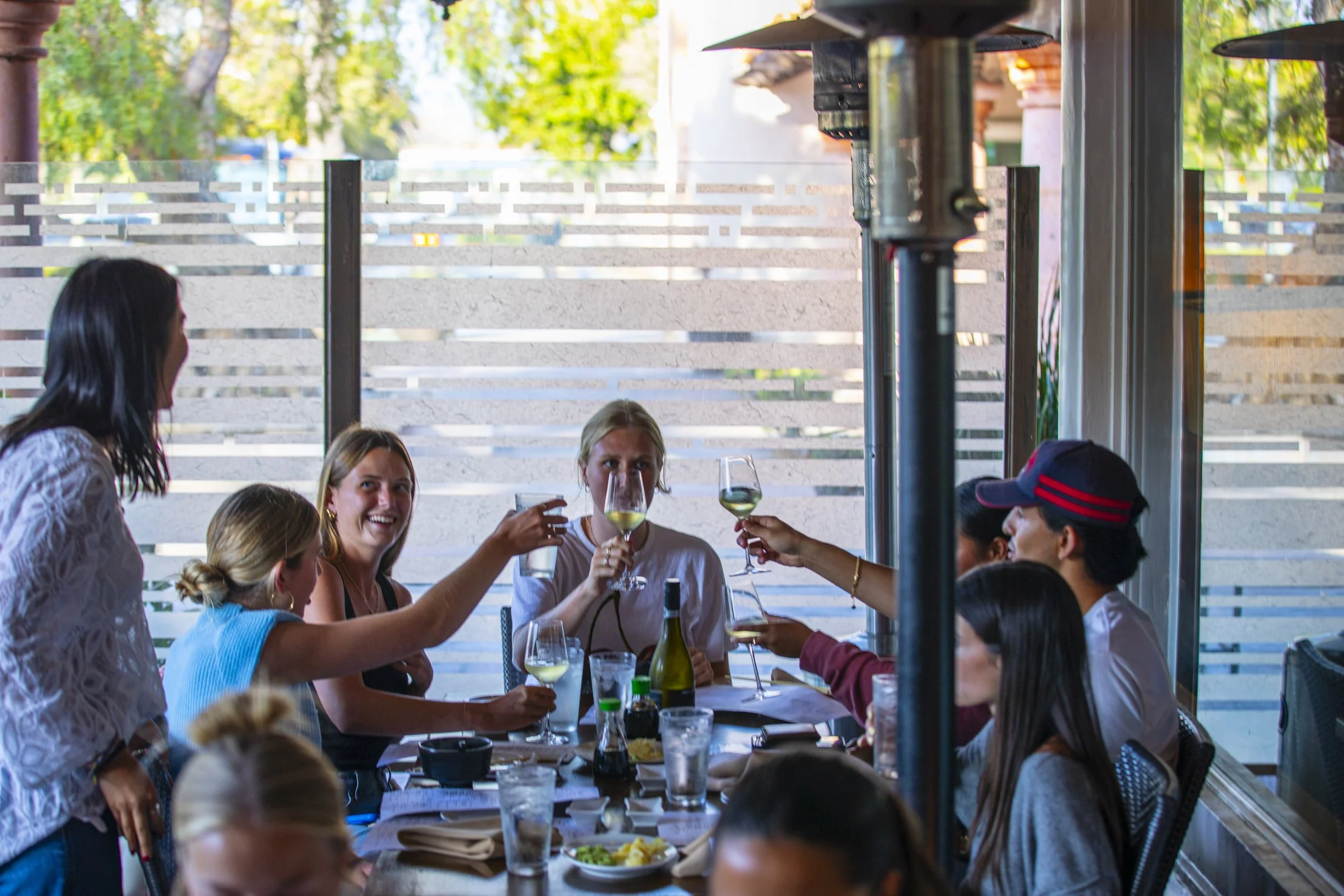 Group of friends celebrating with drinks at a restaurant table