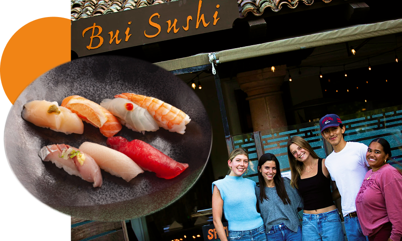 Group of five young people smiling outside a sushi restaurant, with a close-up of a black plate of assorted sushi in the foreground.