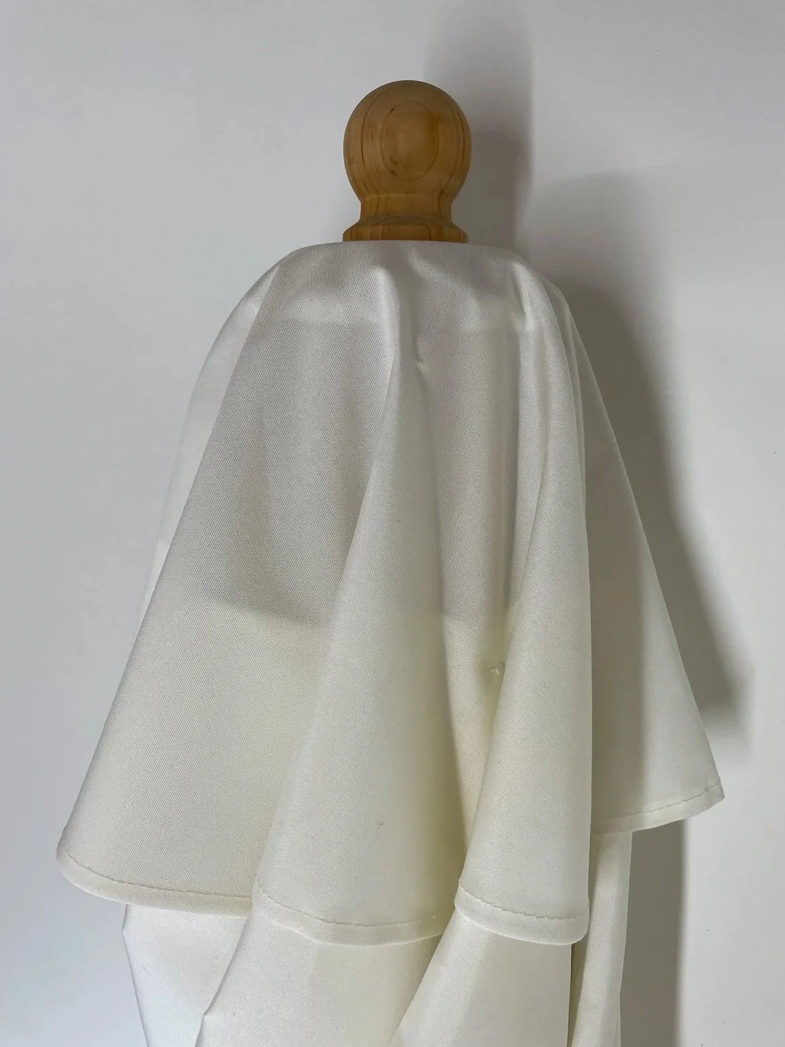 Detailaufnahme des oberen Endes eines weißen Holzsonnenschirms der Manufaktur Chiemsee Schirme in Prien am Chiemsee.