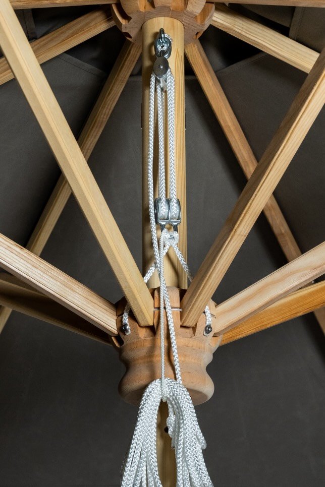 Innenansicht eines Holz-Gestells, das für einen Sonnenschirm verwendet wird, mit Seilzug in der Mitte.