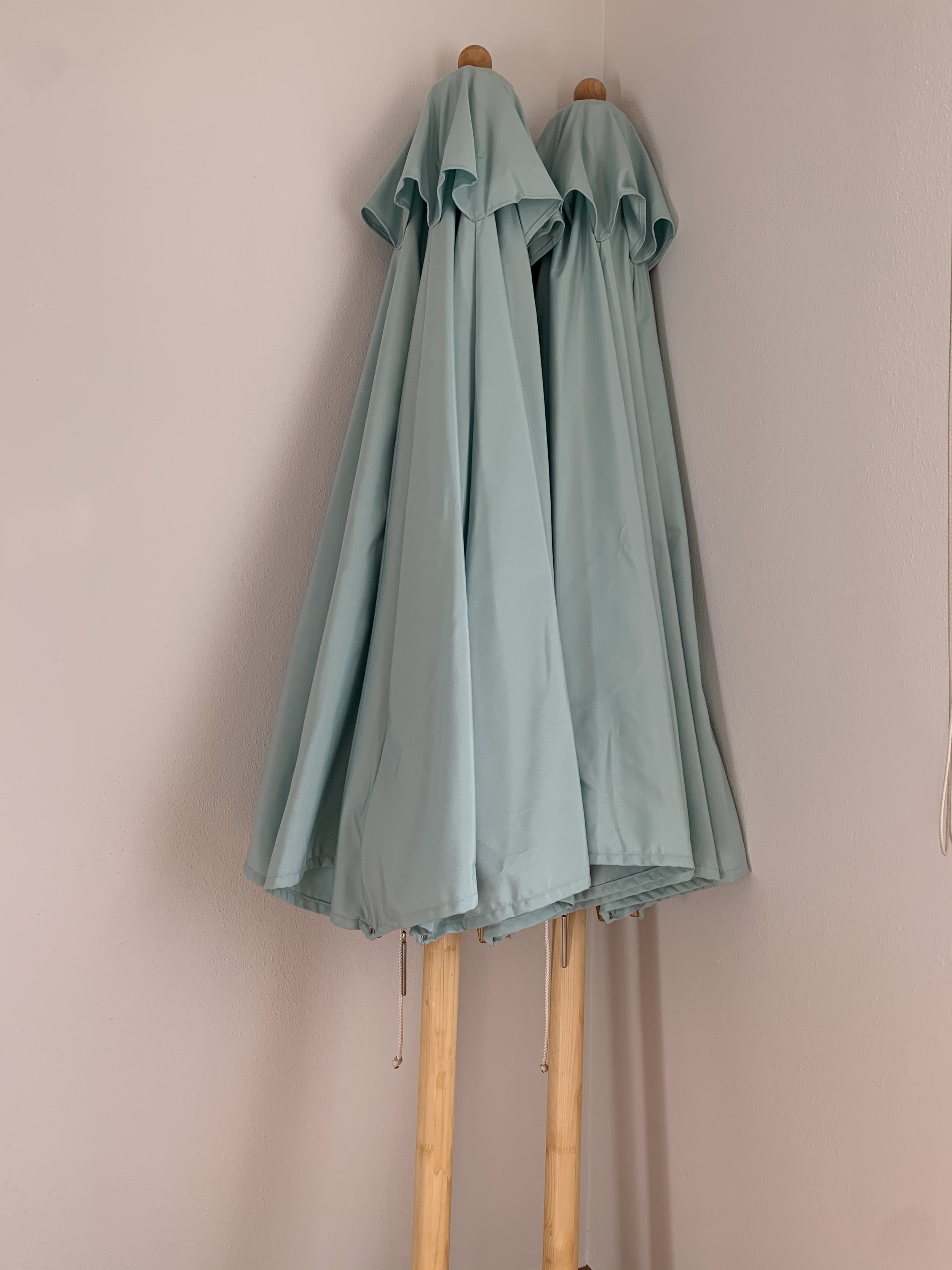 Zwei geschlossene Holzsonnenschirme der Chiemgauer Manufaktur Chiemsee Schirme.