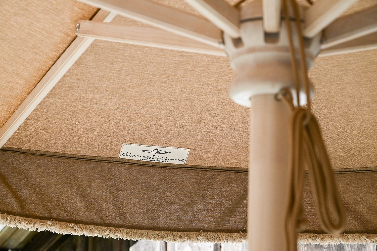 Blick unter einen Sonnenschirm mit Holzgestell aus der Manufaktur von Chiemsee Schirme im Chiemgau.
