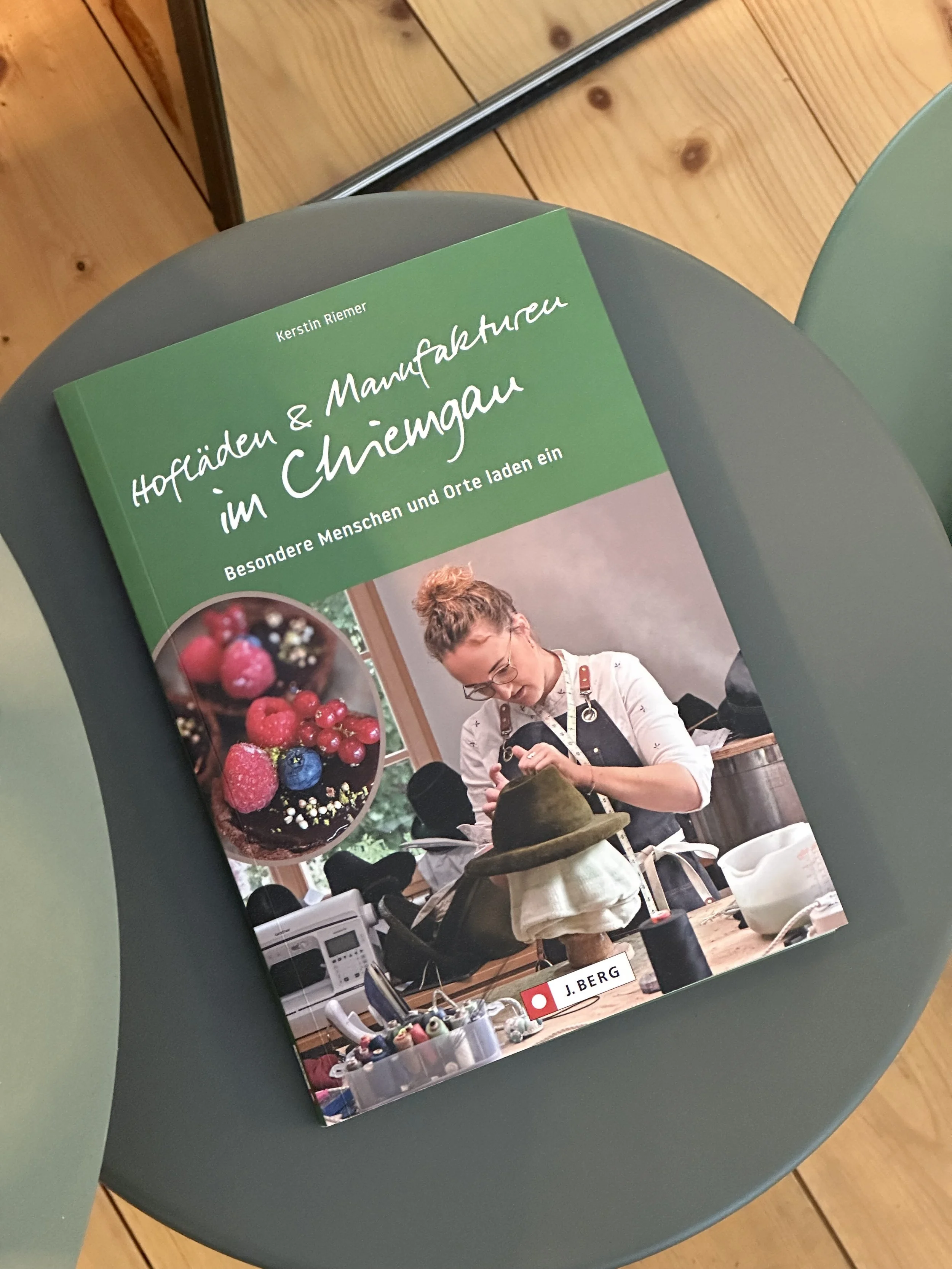 Buch mit dem Titel "Hofläden & Manufakturen im Chiemgau" im Showroom von Chiemsee Schirme.