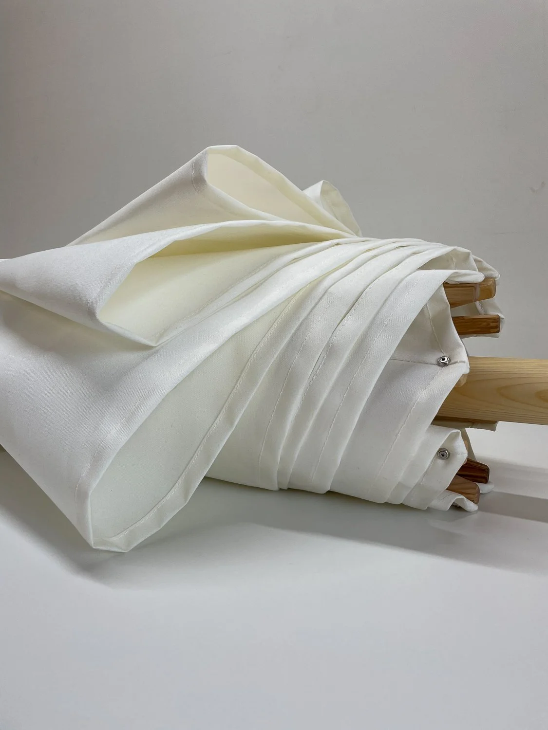 Detailaufnahme eines weißen Holzsonnenschirms der Manufaktur Chiemsee Schirme in Prien am Chiemsee.