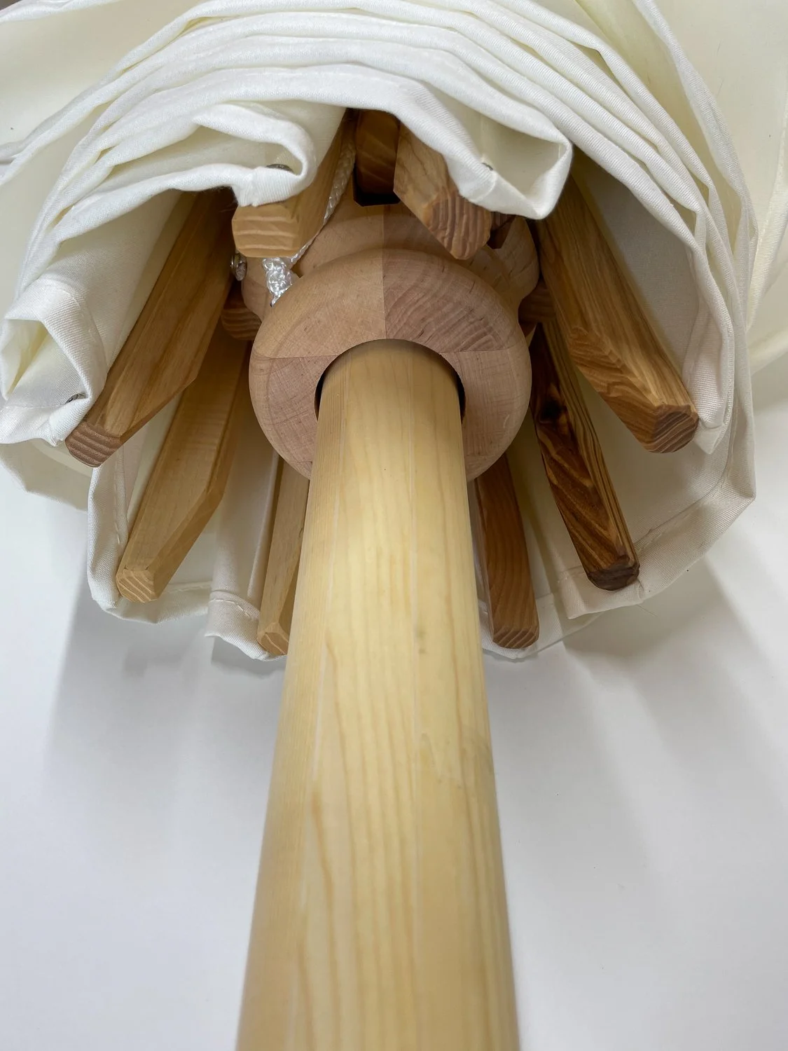 Unterseite des Masts eines Holzsonnenschirms von Chiemsee Schirme.