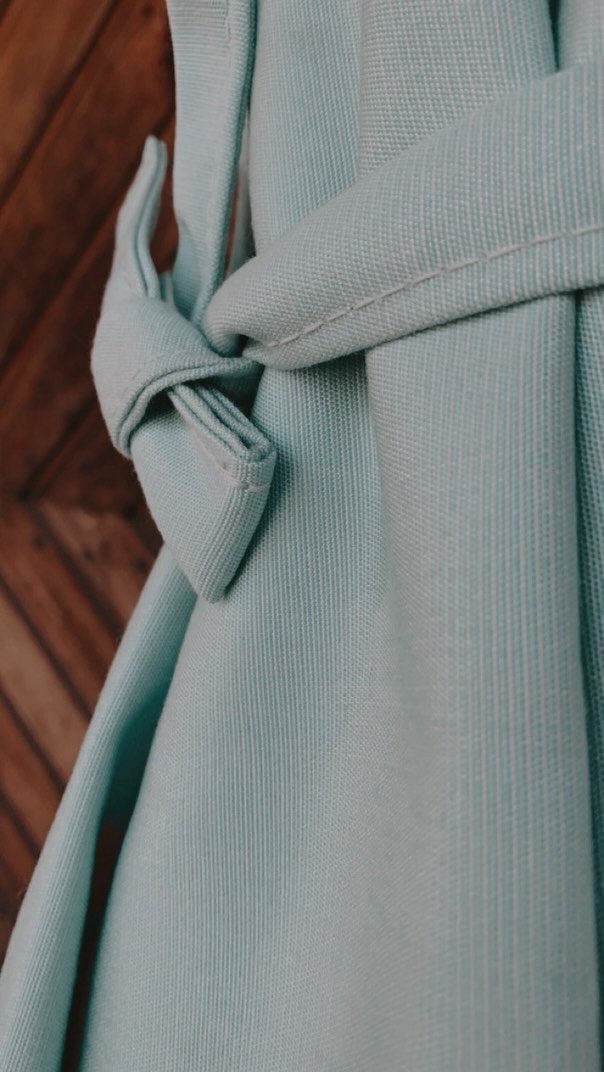 Nahaufnahme eines hellblauen Sonnenschirms der zusammengebunden ist.