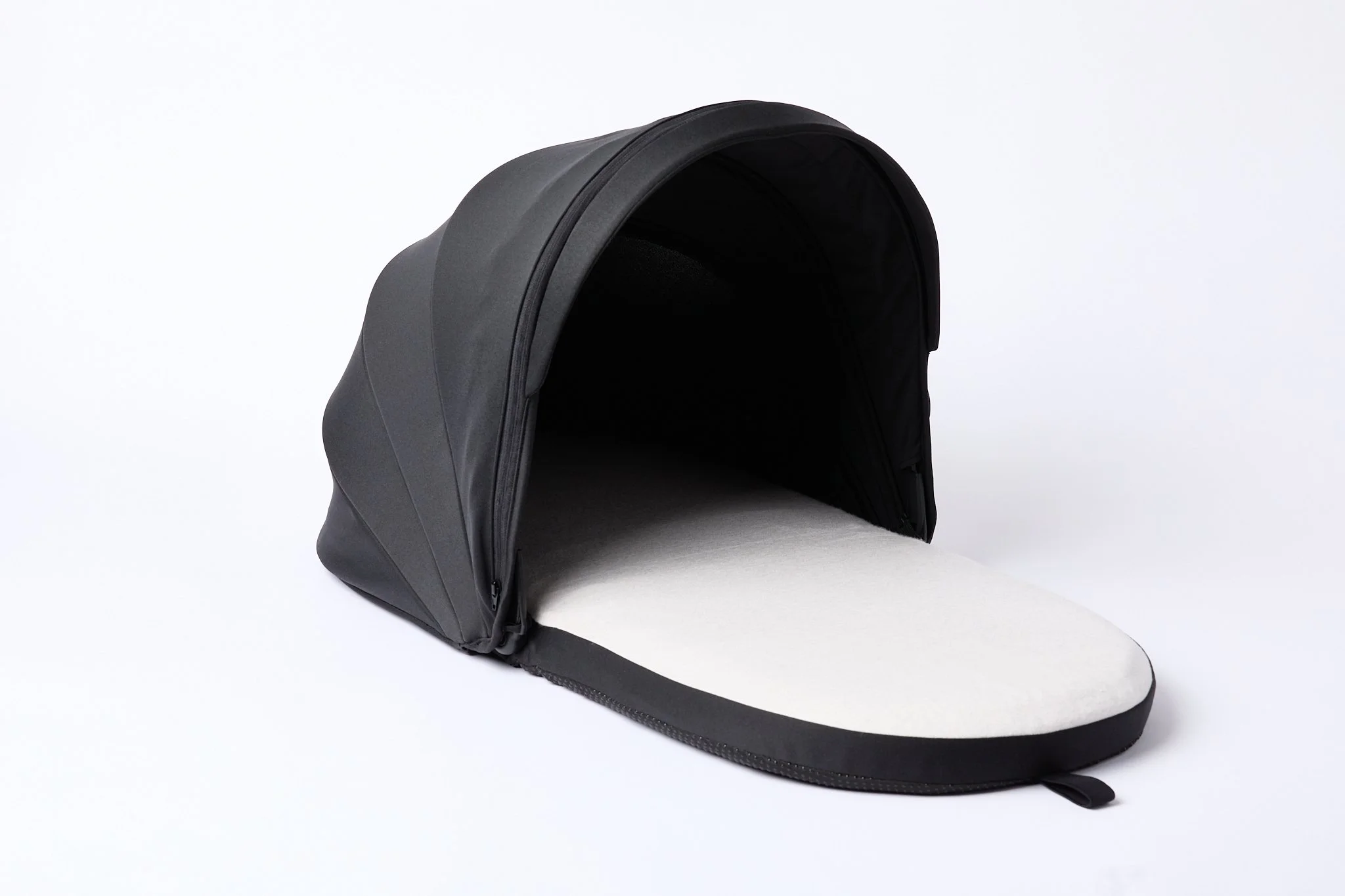 A black and grey DayNapper with firm flat base and blackout air permeable hood, positioned against a plain white background.
