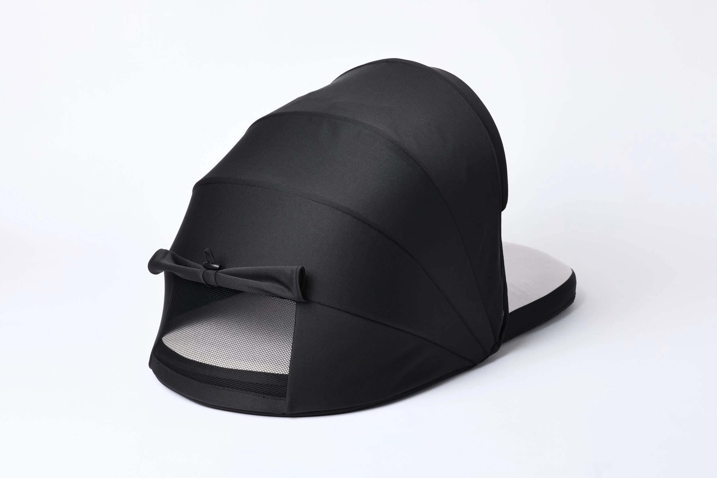 Rear view of DayNapper showing blackout hood and back flap toggled up for extra ventilation and viewing of a baby, set against a plain white background.