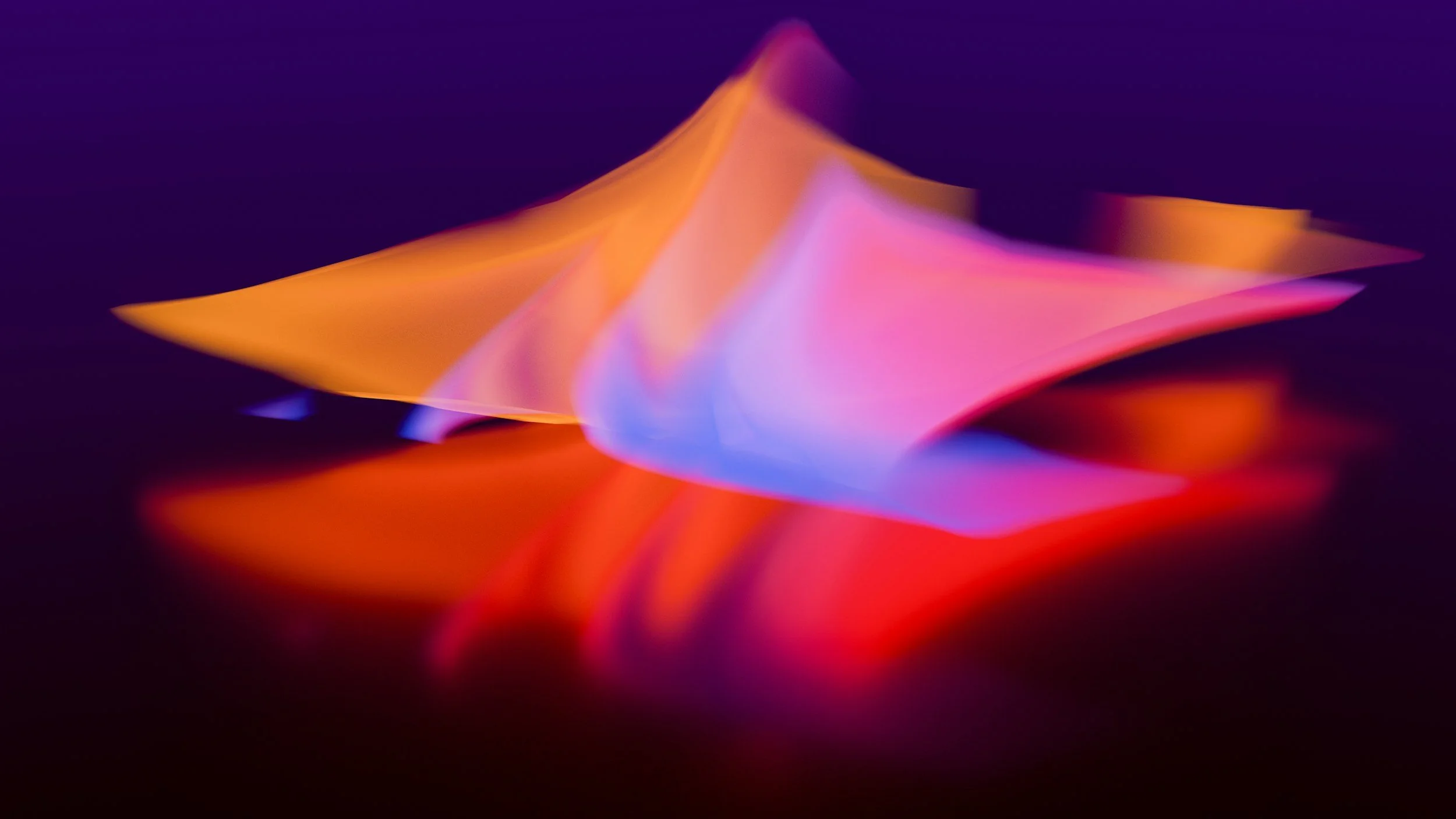 Abstract colorful light patterns resembling a folded paper sculpture reflected on a dark surface.