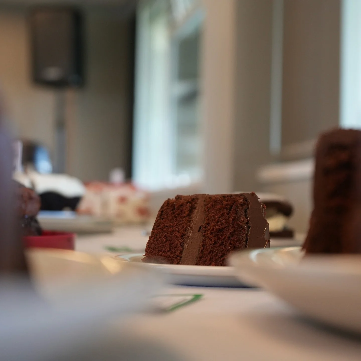 Cupcake with candles and colorful balloons in the background.