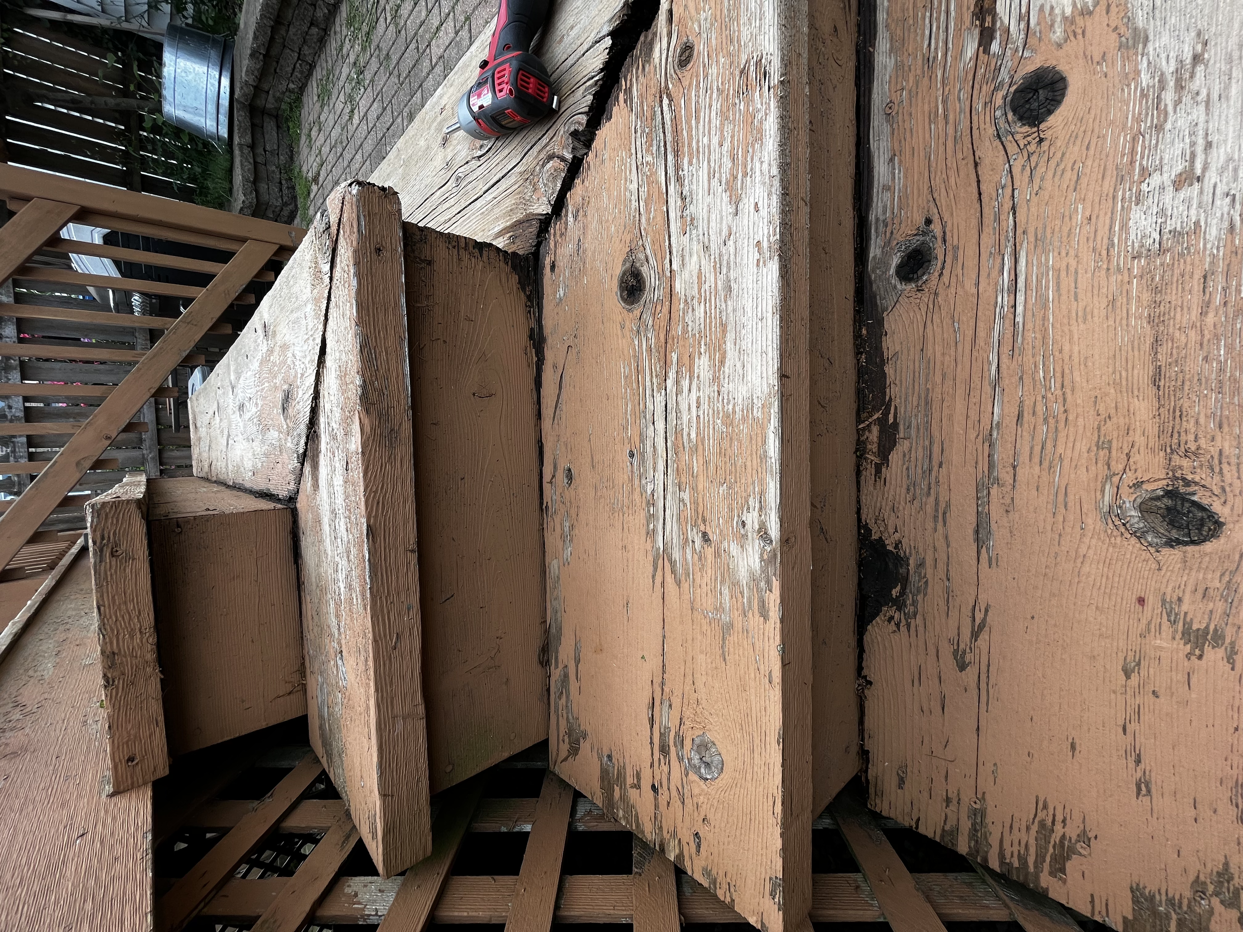 Close-up of a weathered wooden deck with visible knots and rotting wood
