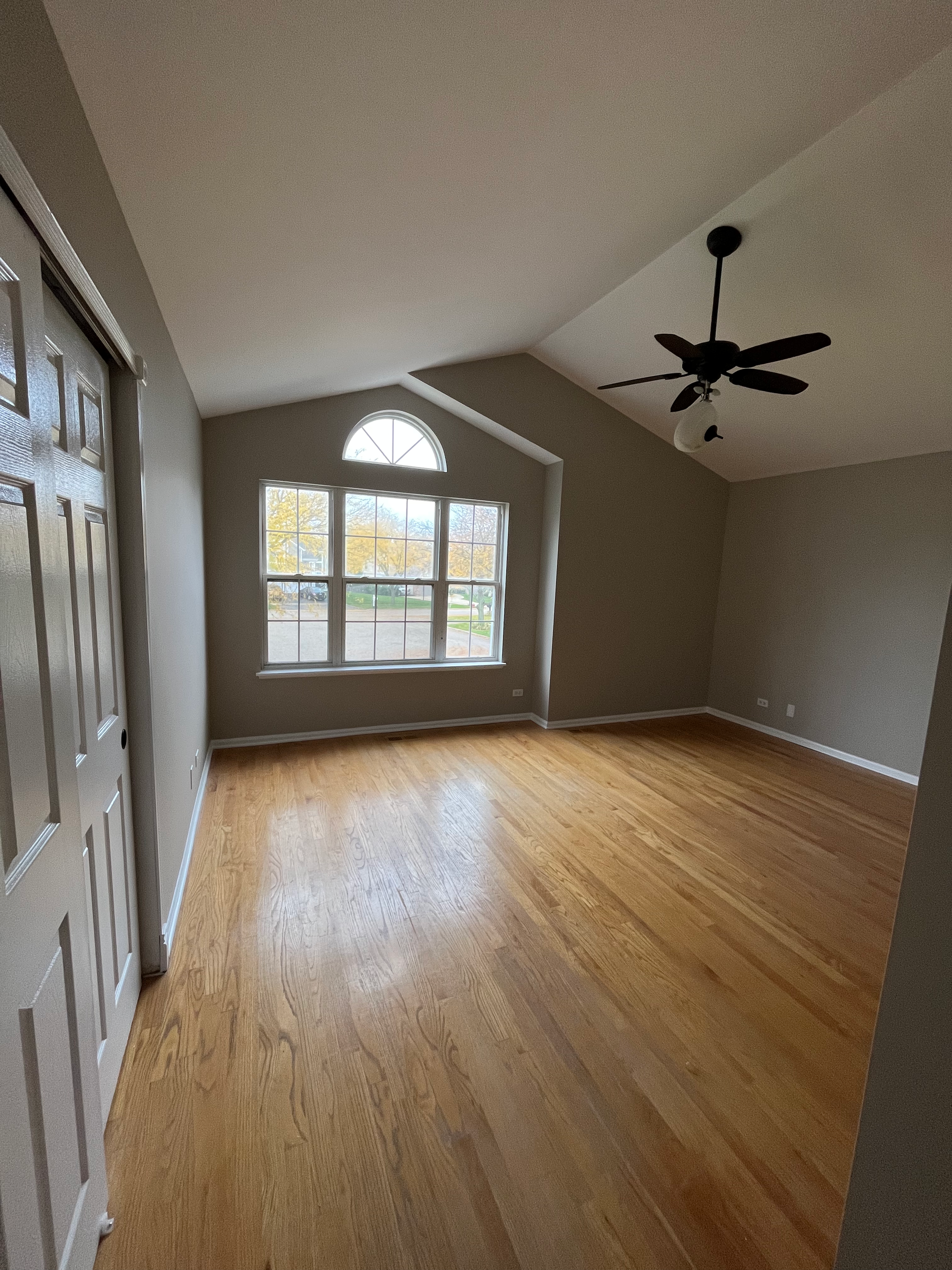 Interior view of room with hardwood flooring and baseboards installed and walls painted