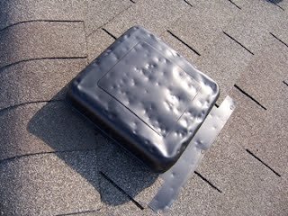 Dented roof vents from hail damage at a residential property