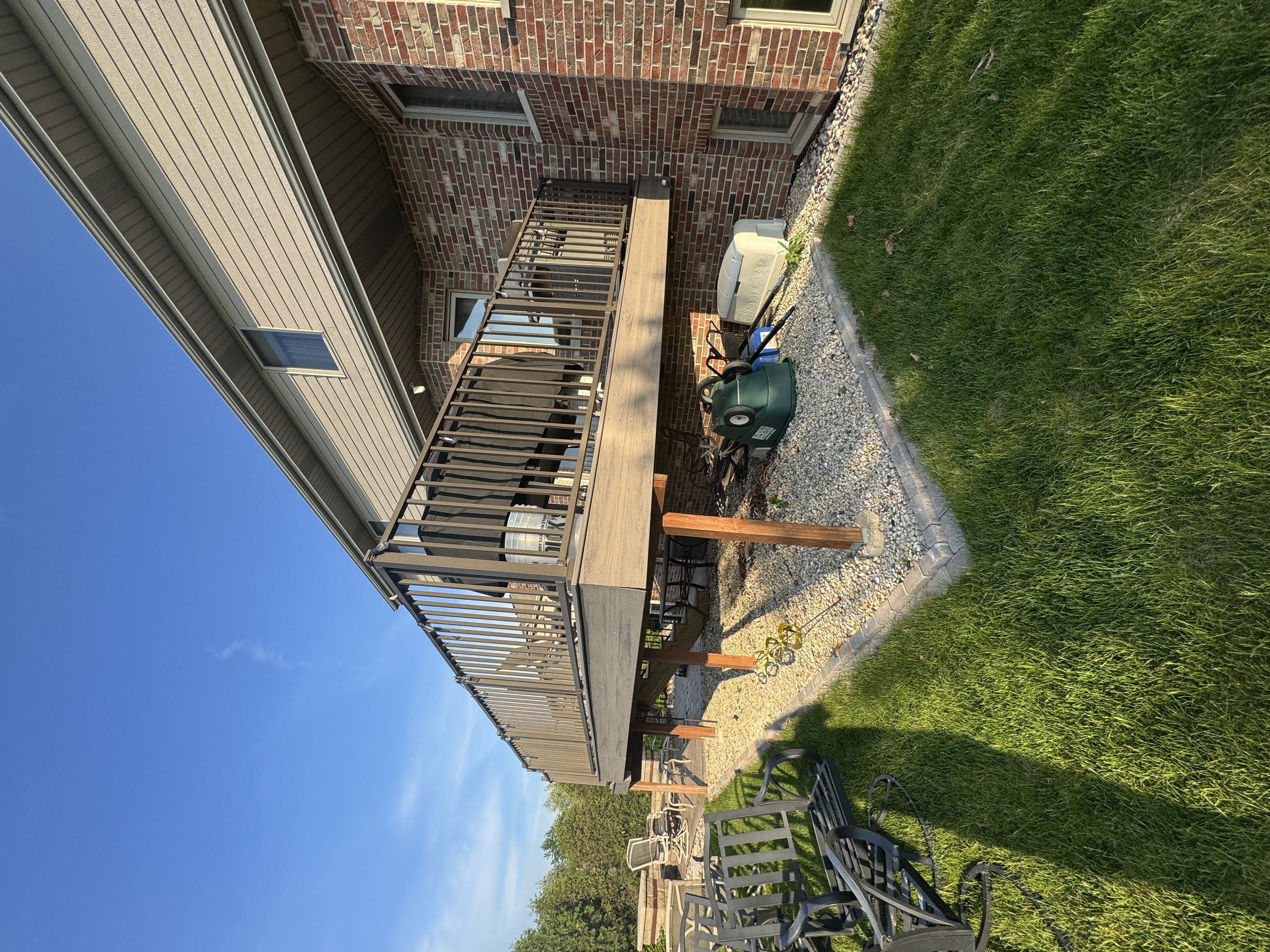 A wooden deck, with professionally painted supports, railings, and decking