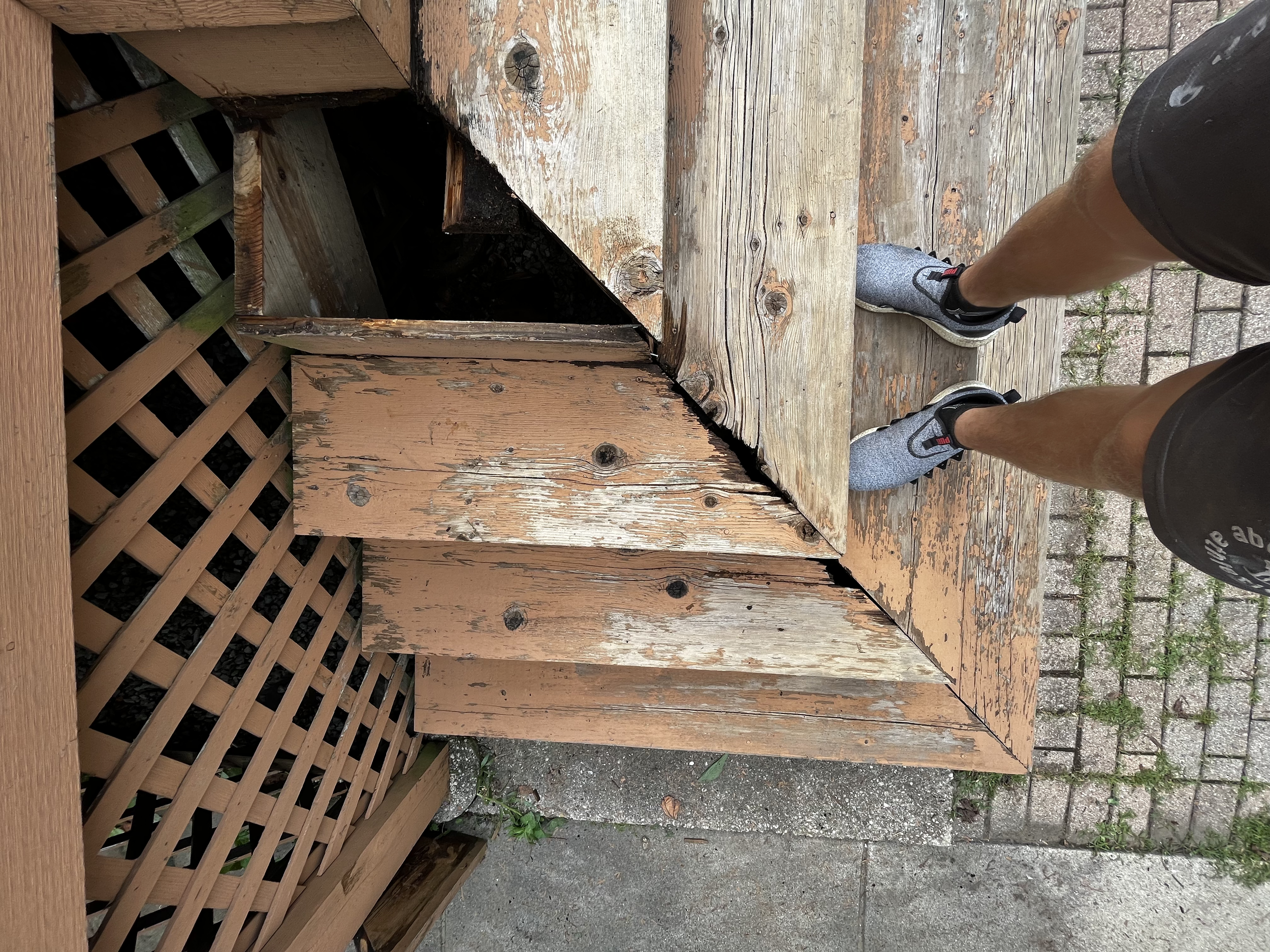 Weathered wooden staircase with a piece removed in preparation for a full repair